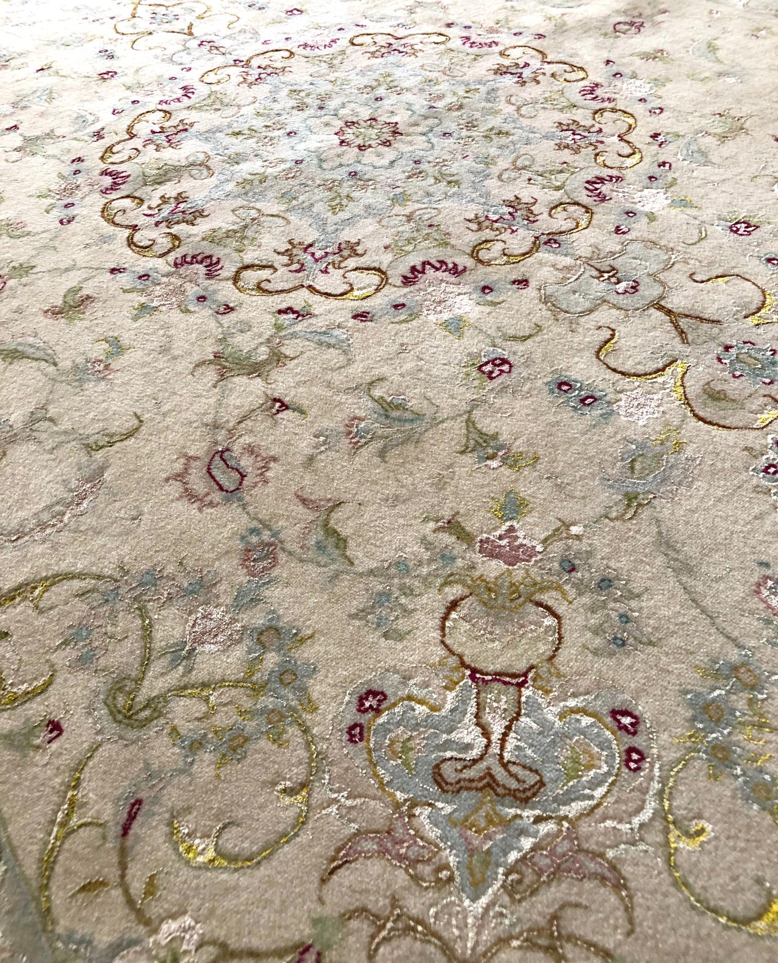 This Persian Tabriz rug has wool & silk pile and cotton foundation. This rug features a beautiful medallion floral design and has cream base color with light pink border. The size is 5 feet wide and 6 feet 9 inch long. This piece has been