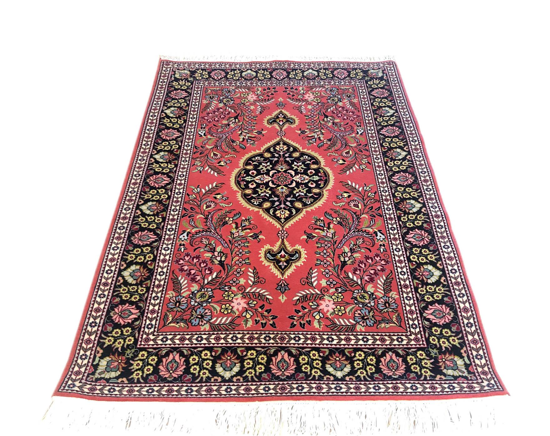 This Persian Tabriz rug has wool and silk pile and cotton foundation. This rug has a medallion floral design with salmon pink base color and black border. The size is 2 feet 11 inches wide and 4 feet 5 inch long. The colors as well as the