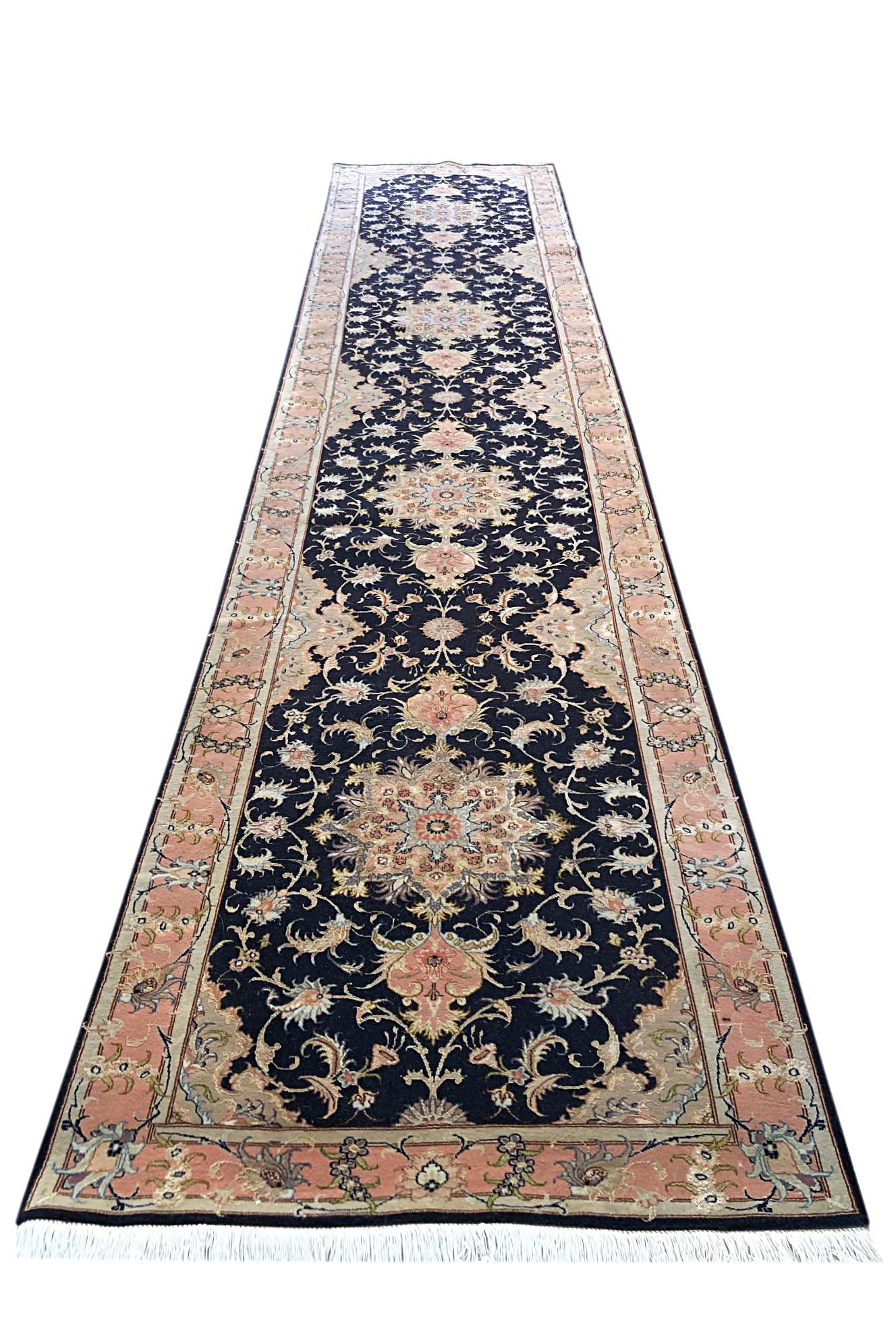 This Persian Tabriz runner has wool and silk pile and cotton foundation. Tabriz rugs are well known for their excellent weaving and design. This rug features a beautiful floral rug pattern that has Black base color with peach border. The size is 3