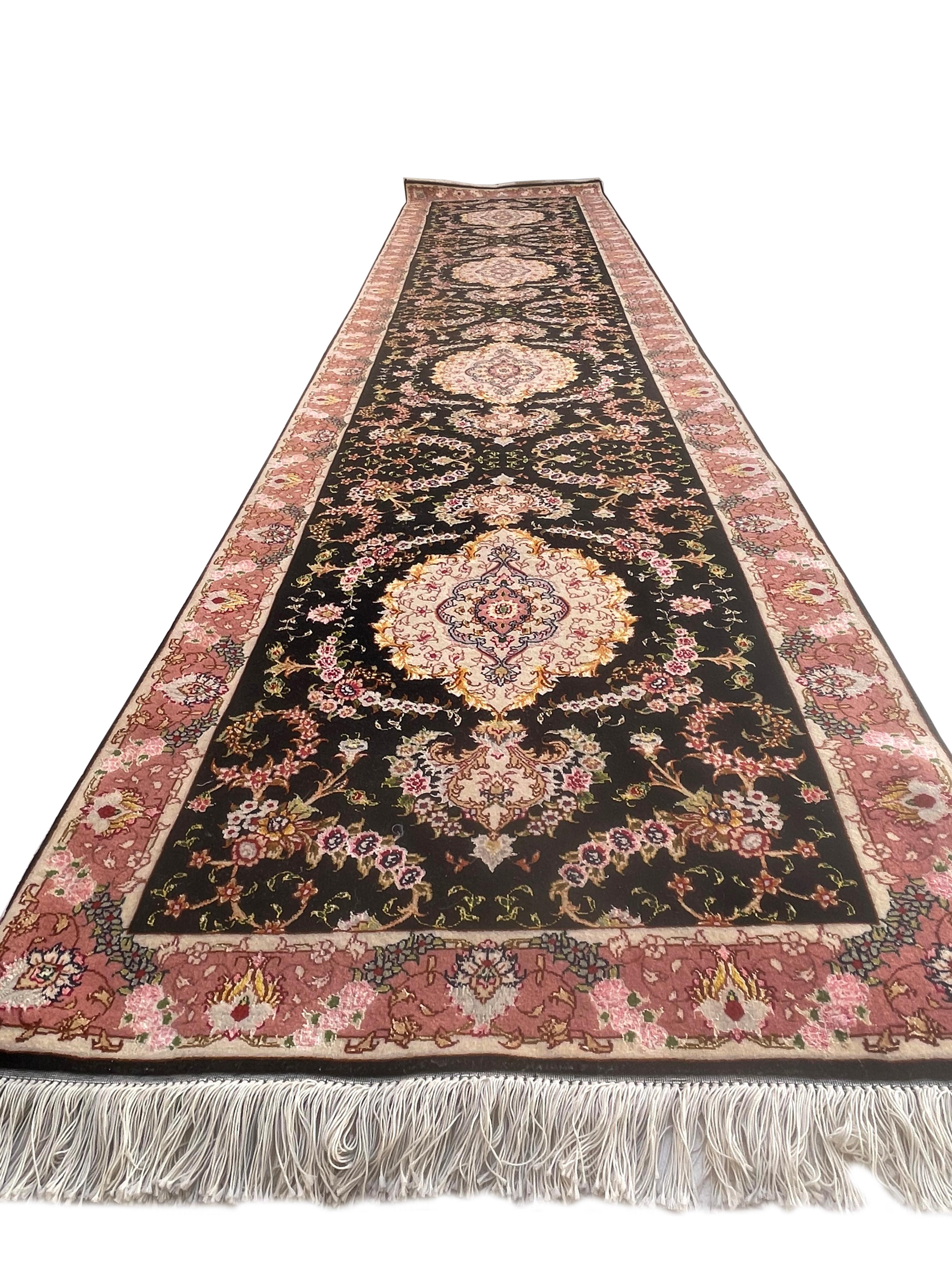 This Persian Tabriz runner has wool & silk pile and cotton foundation. Tabriz rugs are well known for their excellent weaving and design. This rug features a beautiful floral rug pattern that has black base color with salmon border. The size is 2