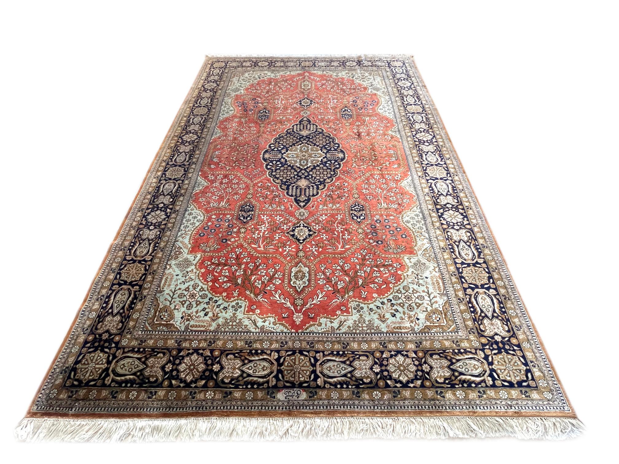 This is a very fine rug weaved in city of Qum, Iran. This rug has silk pile and foundation, with a stunning design and color combination woven onto an orange red background with a dark blue border. The design in this piece is a Josheghan design with