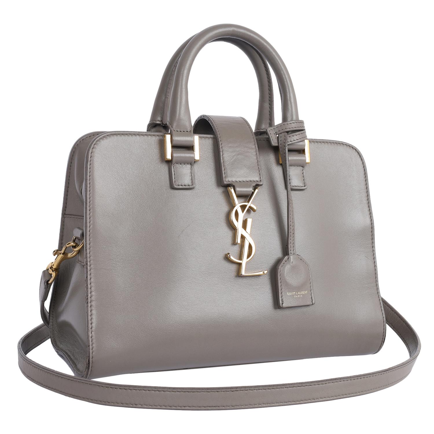 Authentic, pre-loved Saint Laurent YSL Calfskin Monogram Baby Cabas in Grey. This lovely handbag features smooth calfskin leather, rolled leather top handles, an optional removeable shoulder crossbody strap, gold YSL snap closure and zipper top