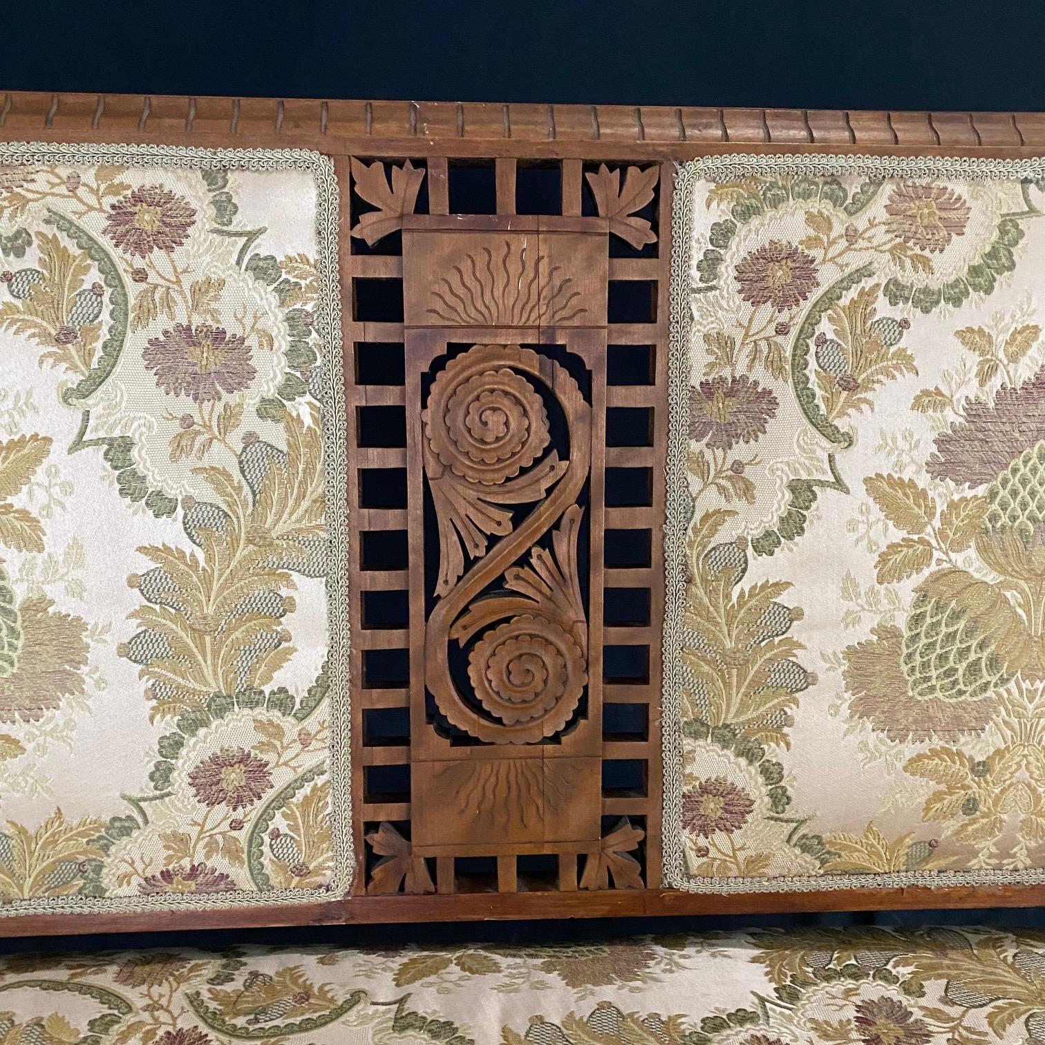 An Eastlake period sofa loveseat or settee centered with a stunning pierced crest having a pierced floral motif with the shape mirrored in the arm pediments. Beautiful outward rolled arms are finished with wooden panels carved with scrolled details,