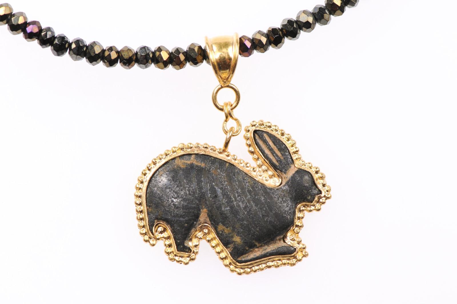 An authentic Roman bronze rabbit fragment (circa 1st-3rd century AD), with the contemporary addition of the 21-karat gold bezel. This ancient bunny in bronze has the sweetest set of ears and a beautiful dark patina, set within a custom 21-karat