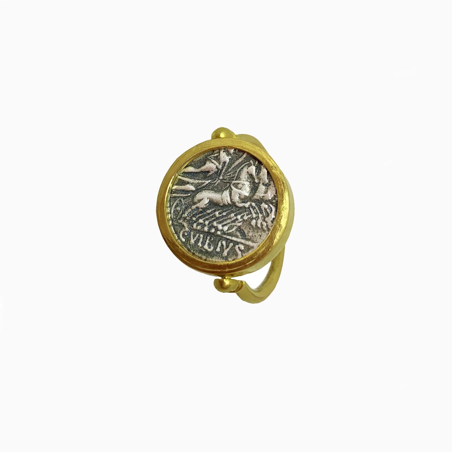 In this 18 Kt  revolving double face gold ring  is mounted  an authentic roman coin ( silver denarius ) depicting God Apollo. In the reverse side of the coin there is Minerva who leads a quadriga at a gallop. The coin was minted by consul Vibio