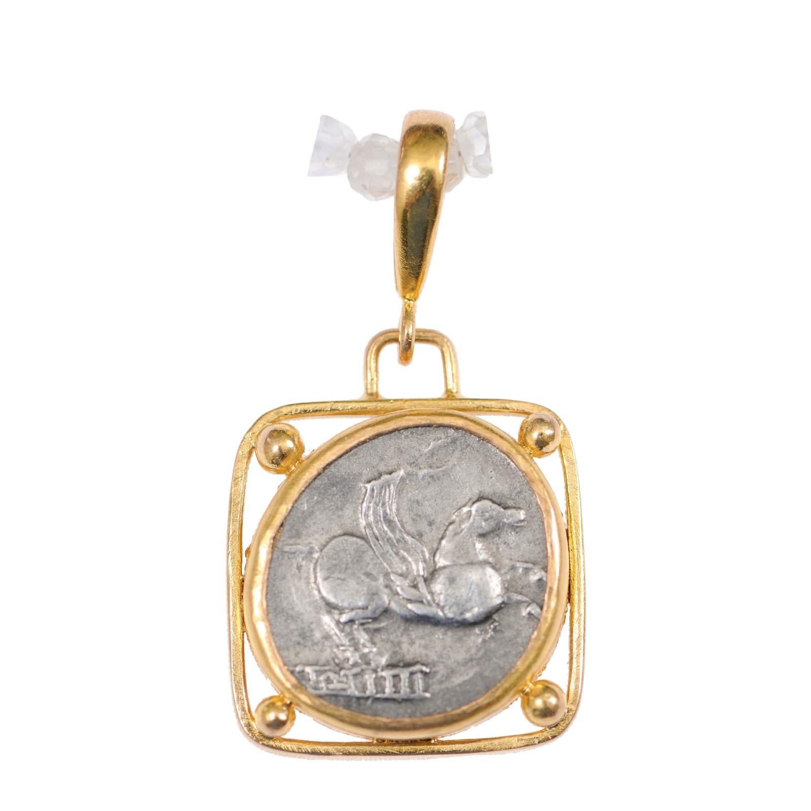 An authentic Q. Titius, silver denarius coin (Rome, circa 90 BC), set in a custom 22-karat gold bezel, suspended within a squared bezel with gold bead accents at each corner, and 22-karat gold bail. The obverse, or front, side of this coin features