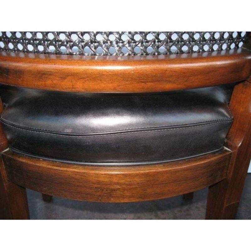 Set of 6 side chairs plus 2 matching armchairs, upholstered in black leather with a beautiful sheen and featuring airy canning. It has original stamp John Stuart, New York Grand Rapid. The dimensions below apply to the armchairs. The difference in