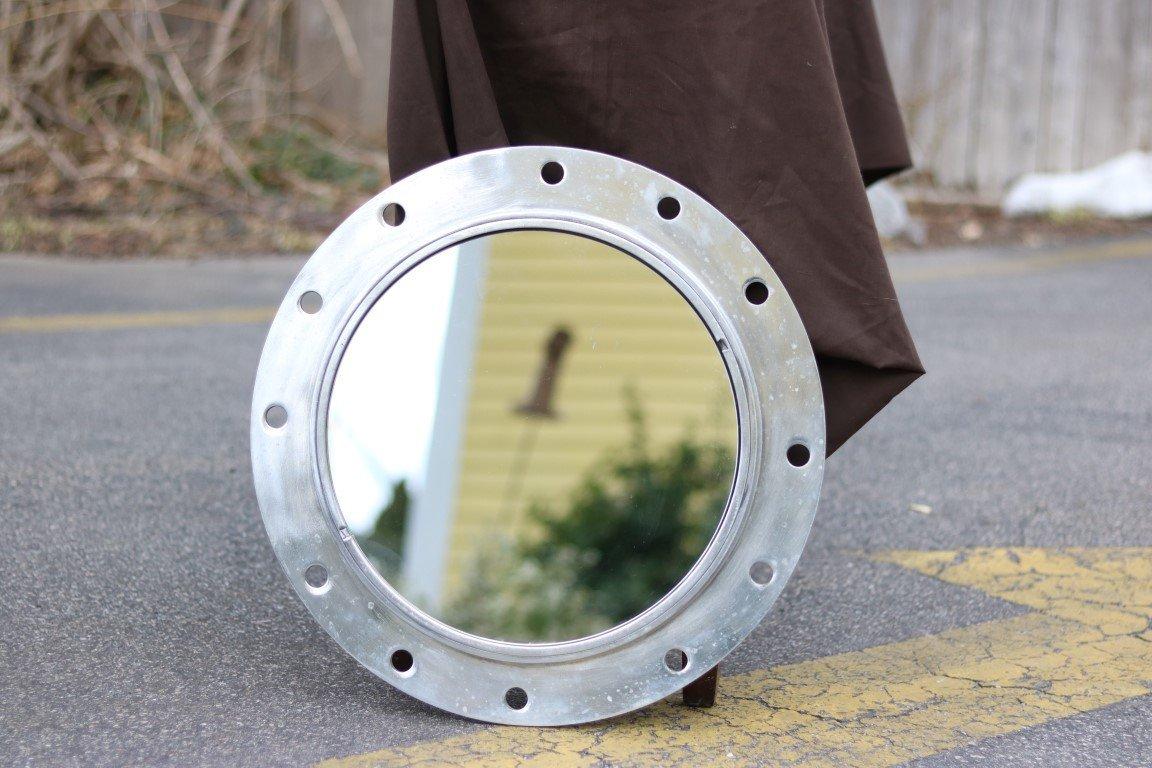 Aluminum ships porthole with polished finish fitted with a glass mirror.

Overall dimensions: Diameter 19.