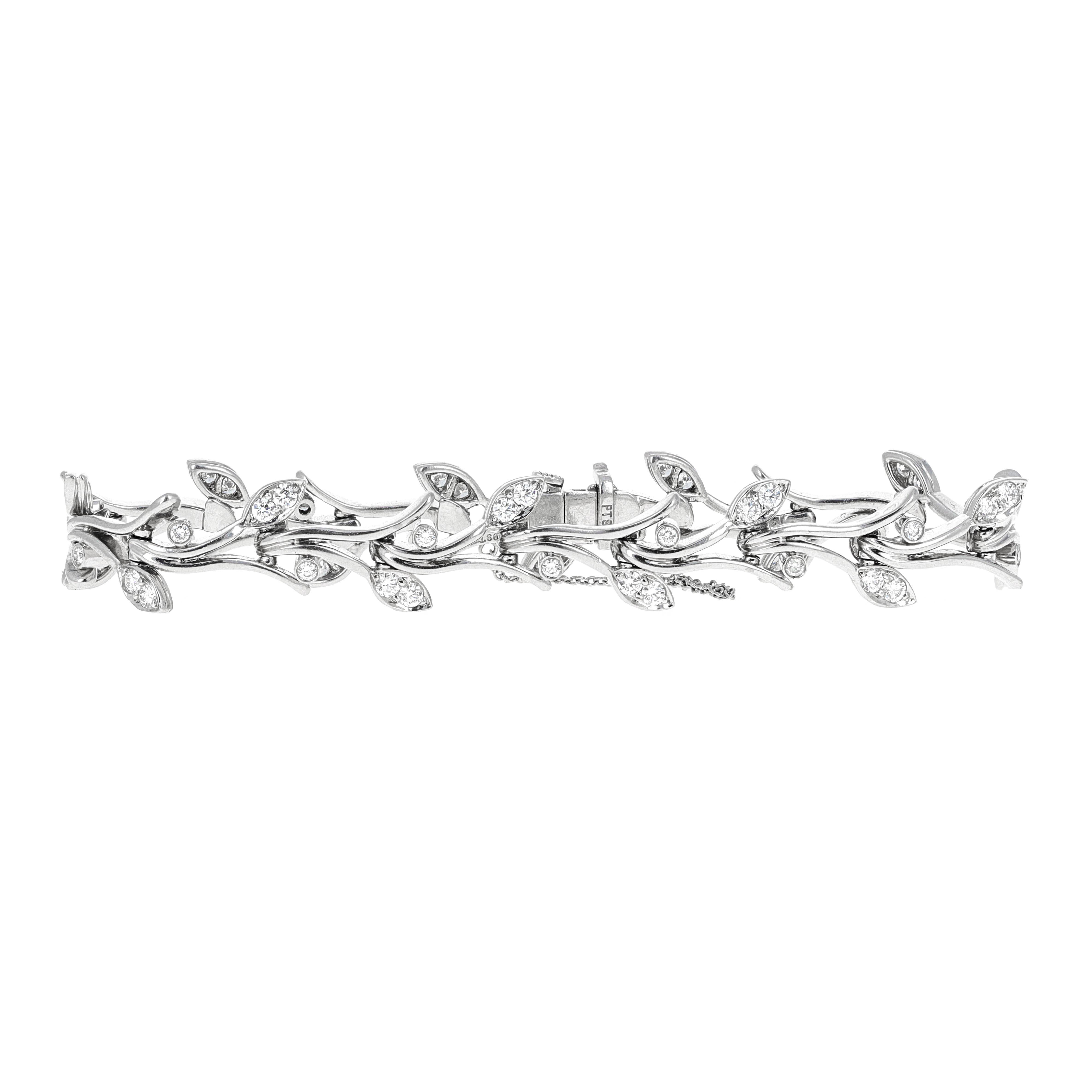 Authentic Tiffany & Co, platinum diamond leaf tennis bracelet. The bracelet has 54 round brilliant white diamonds that are eye clean. There is an estimated 1.15 carats total weight in diamonds. The bracelet measures 7 inches and has a saftey chain