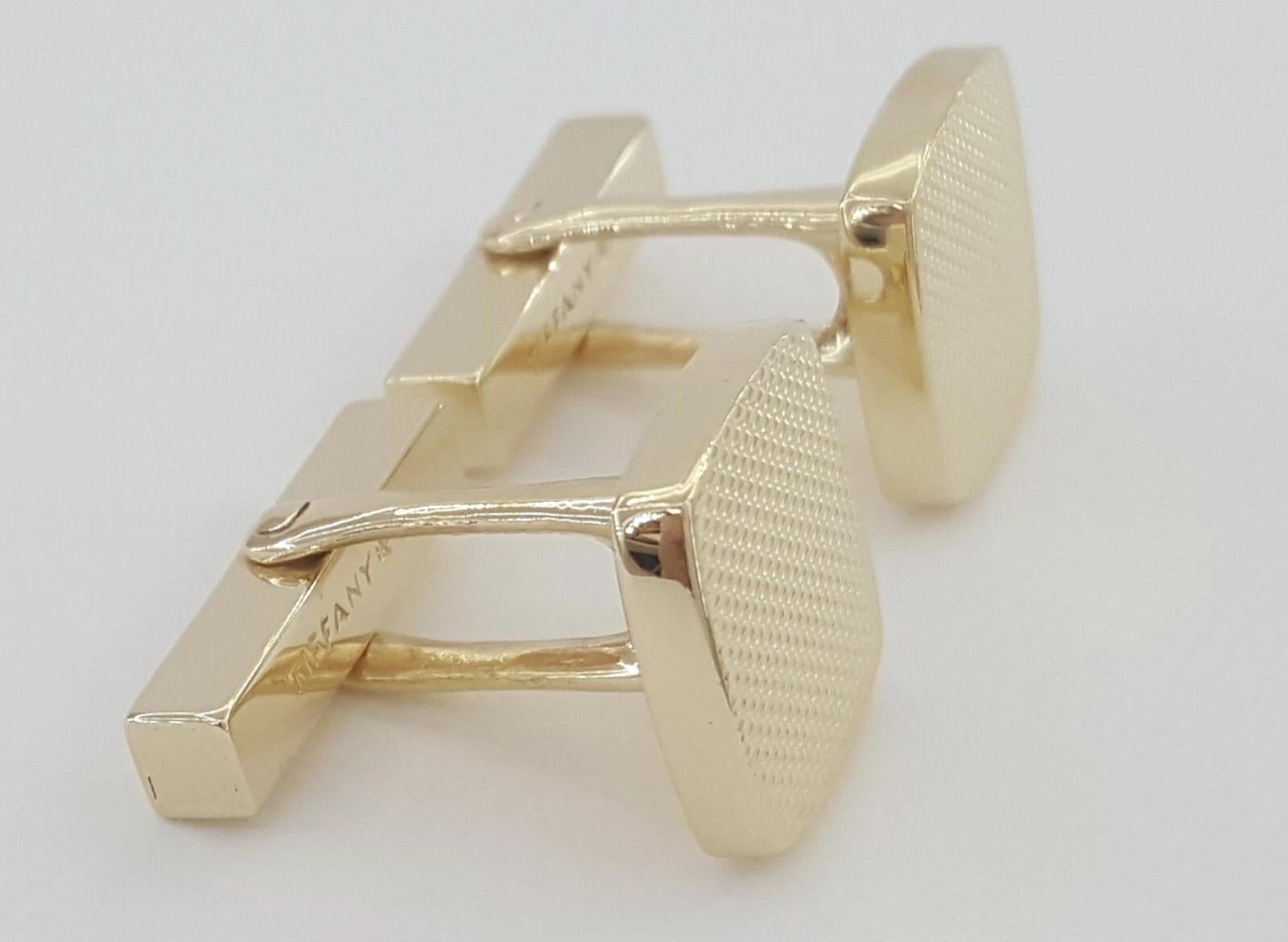 These vintage Tiffany & Co. cufflinks are a timeless accessory crafted in solid 14K yellow gold. Measuring approximately 14mm across, they feature a classic square design and are stamped “Tiffany & Co.” and “14K” on the reverse.

Weighing a total of