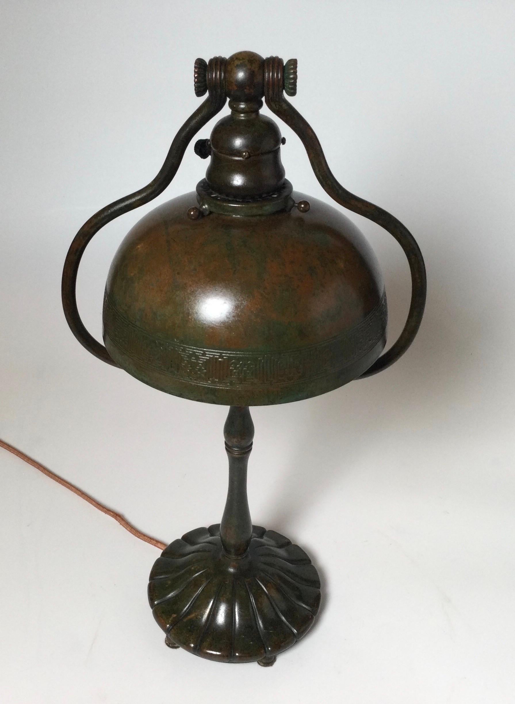 Tiffany Studios Bronze Schreibtischlampe mit original Bronze Zodiac Muster Schatten. Die verschnörkelte, bauchige Harfe steht auf einem kreisförmigen, kannelierten Sockel mit den originalen, kreisförmigen Kugelfüßen, originale, warme Patinierung.