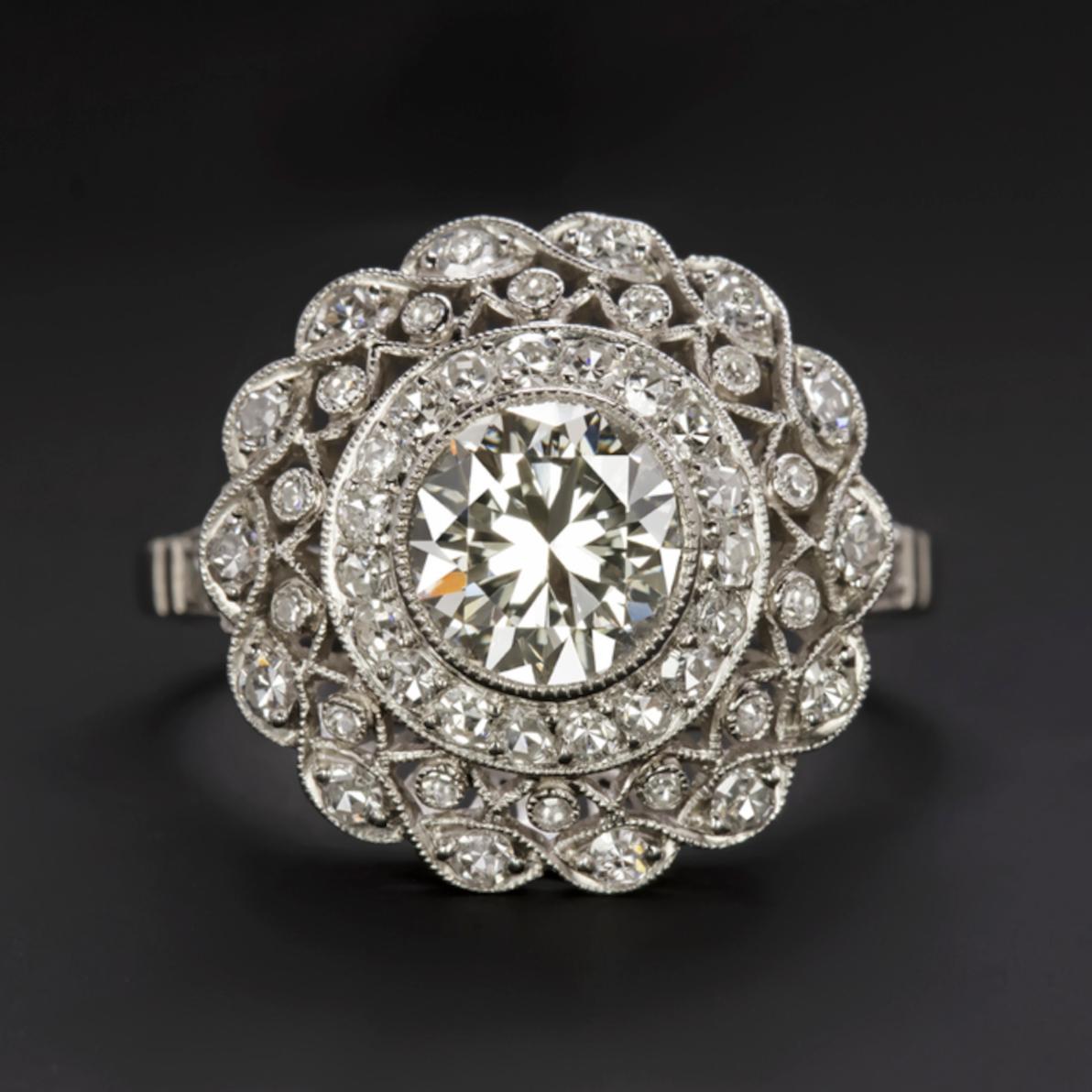 incredibly detailed diamond ring features a phenomenally brilliant 1.30ct old European cut diamond center complemented by a richly detailed diamond encrusted platinum setting. Fiery, bright white, and eye clean, the center diamond was cut by hand a