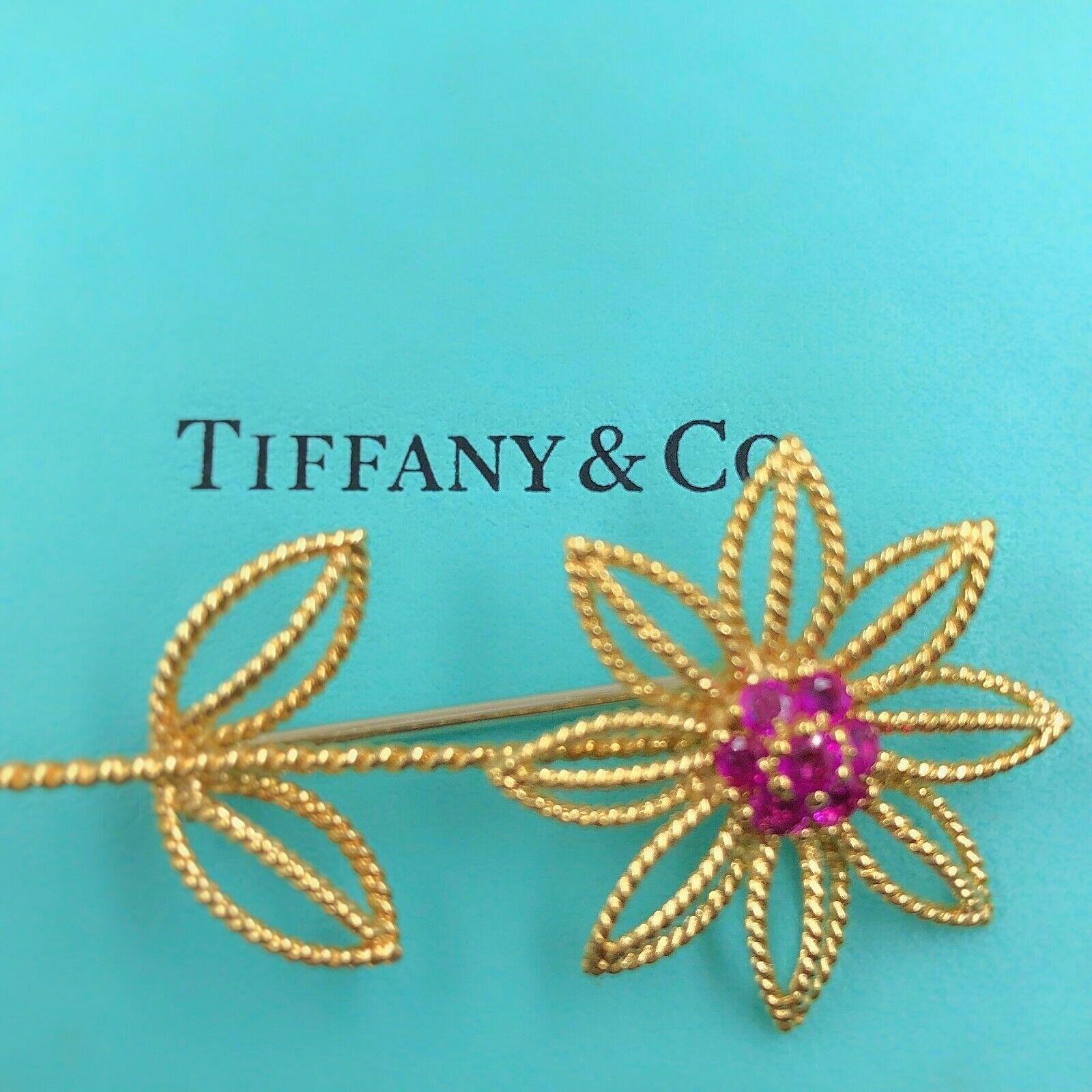 Tiffany & Co.
Style: Pin / Brooch
Metal: 18k Yellow Gold
Measurements:  2 Inches X 1 Inches
Gemstones:  7 Bright Red Rubles weighing approximately 1/2 tcw.
Hallmark:  