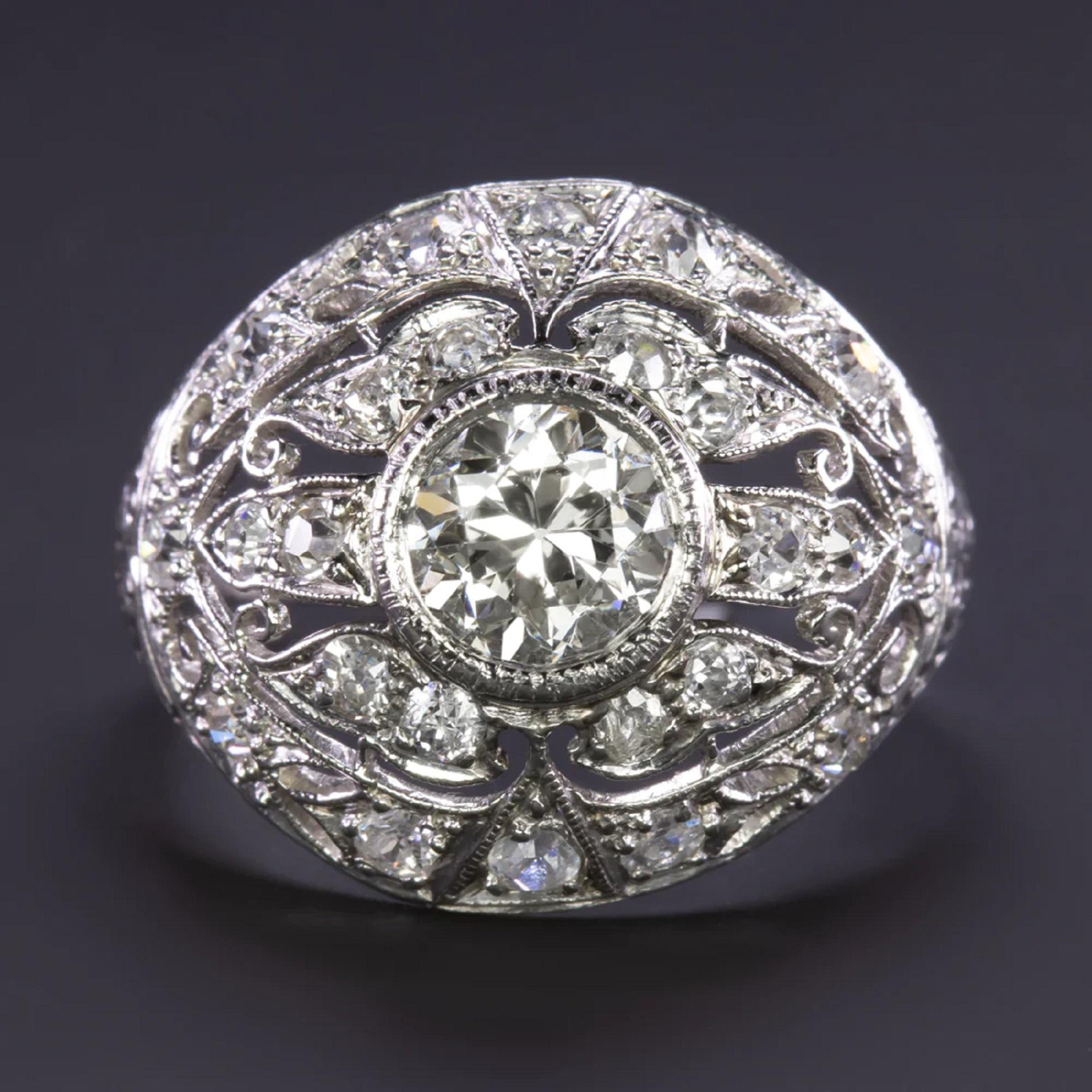 vintage cocktail ring is an absolute sparkle bomb with a 1.31ct old European cut diamond center and 0.83 additional carats on the sides! Crafted in the Art Deco era, the platinum setting is beautifully designed with a domed shape, engraving,