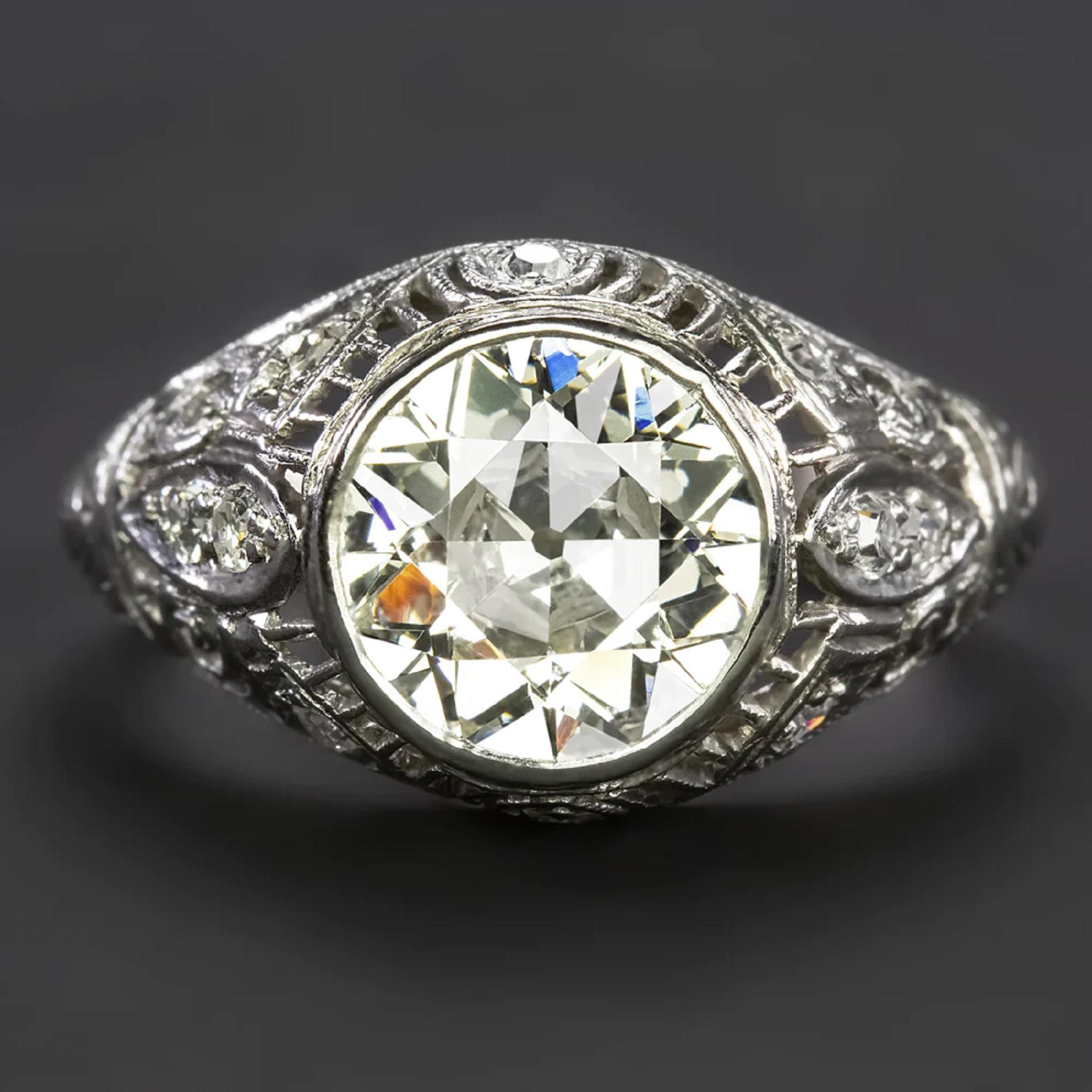 Crafted in the Art Deco era, this vintage engagement ring has a commanding presence with a dazzling 2.27 carat old European cut diamond center! The platinum setting is beautifully detailed with a diamond studded, intricate filigree dome