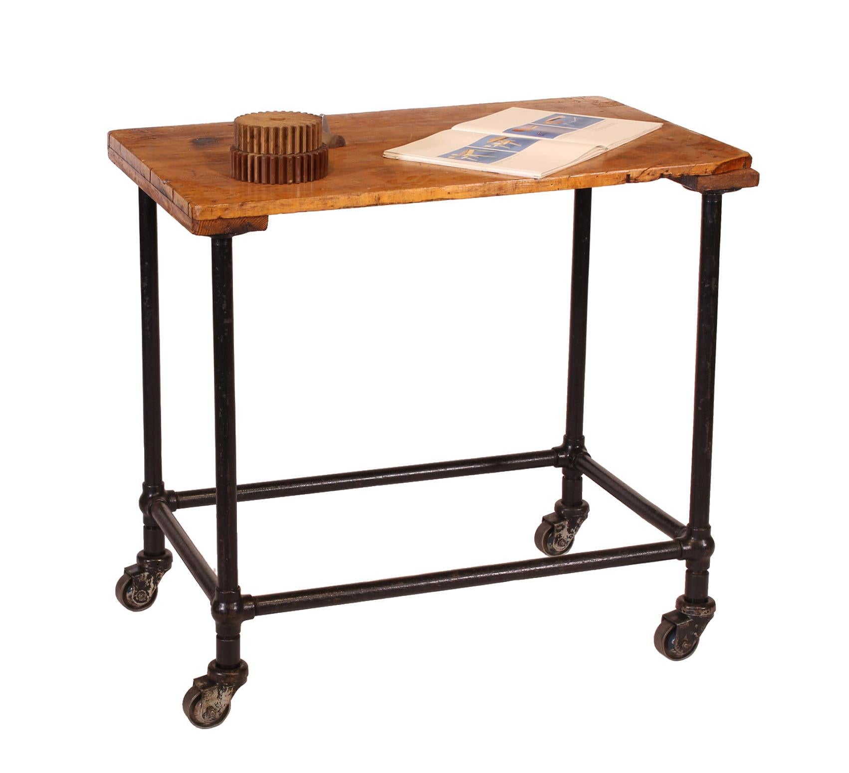 Vintage industrial authentic factory printing cart. Features cast iron bubble joints, steel tubing, cast iron wheels, and maple top on plywood stretchers. Casters read 'Darnell Caster Long Beach CAL. Chicago-New York'. Tabletop measure 1