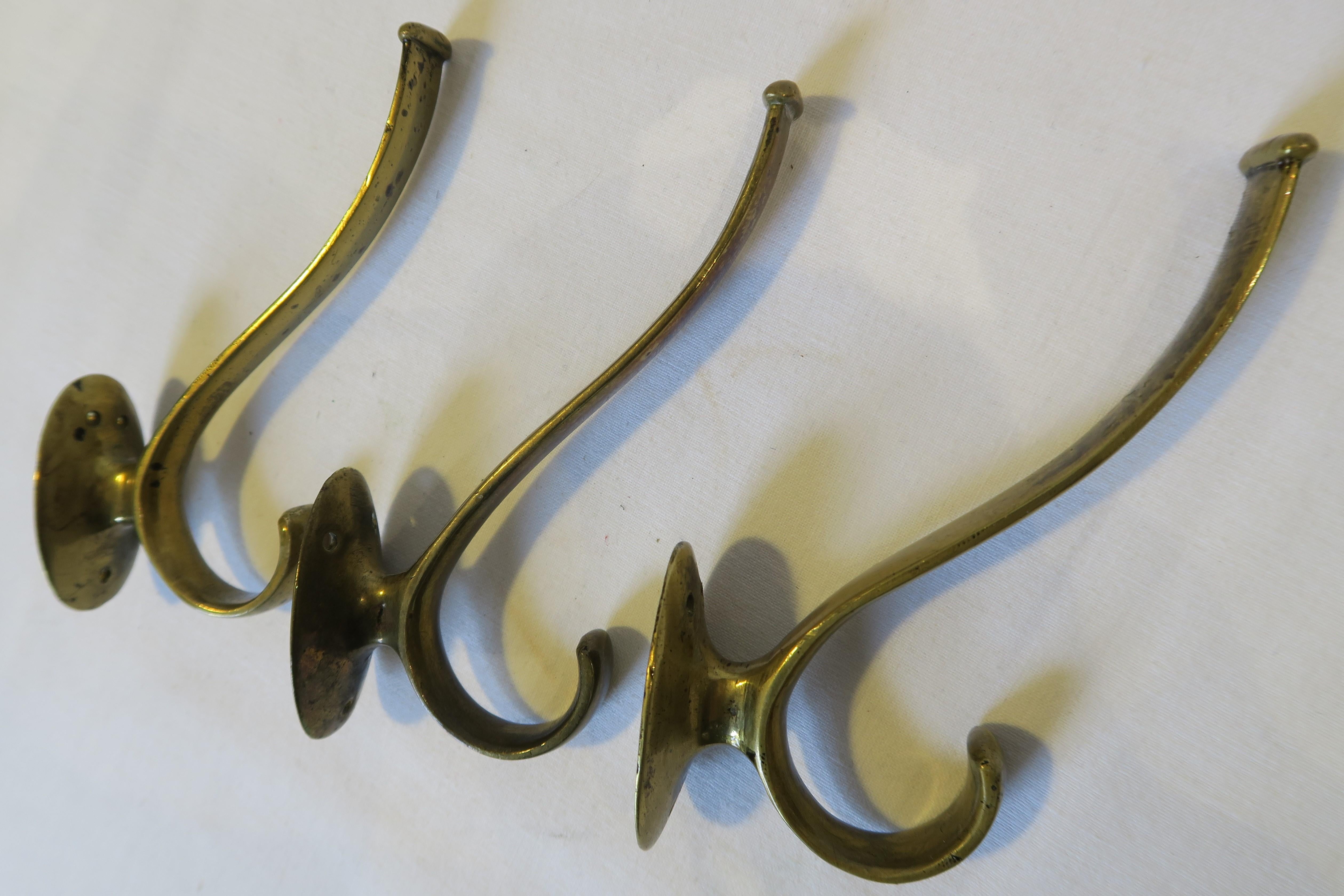 For sale is a beautiful set consisting of three wall mountable Art Nouveau coat hooks. The items were hand-crafted from brass and designed by the renowned Wiener Werkstätte in Austria. They are examples of the typical style of the 20s and 30s and