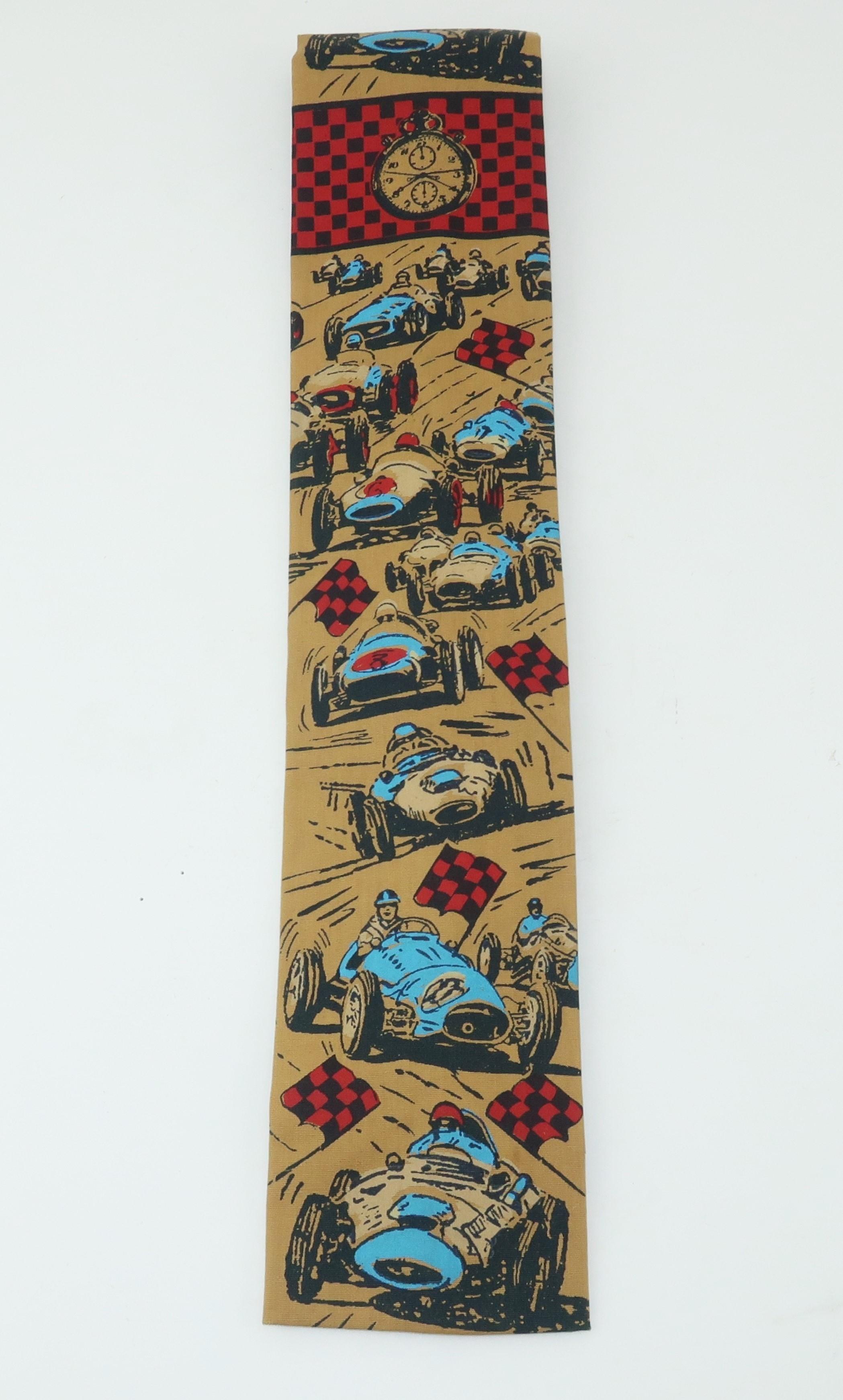 Rooster creates a hand printed cotton men’s necktie with a novelty auto racing theme a la ‘24 Hours of Le Mans’.  The camel color background is accented with cars, drivers, checkered flags and stop watches all in shades of electric blue, red and