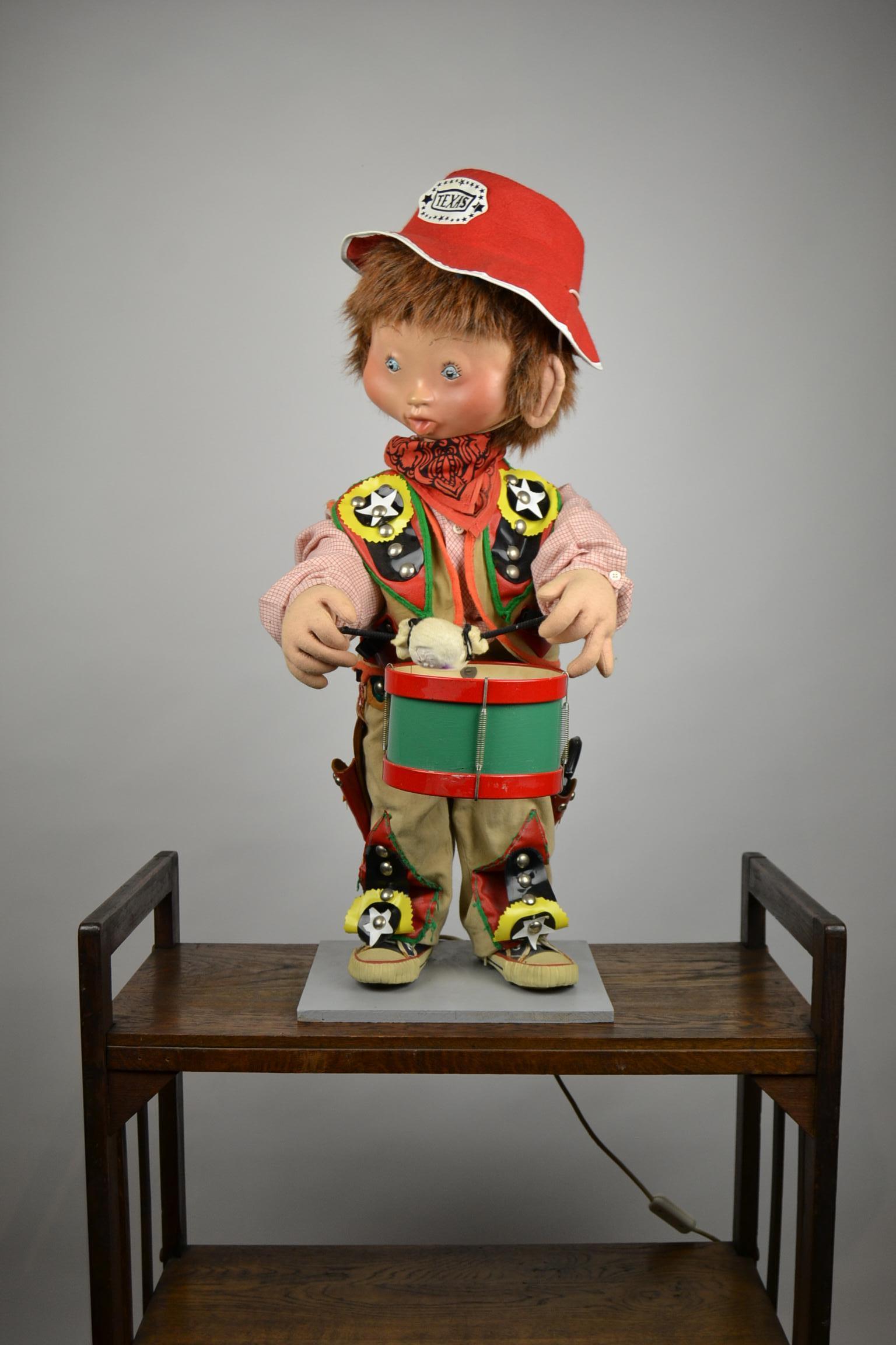 1960s vintage automaton of a Texas cowboy doll playing drum.
Mechanical cowboy doll, moving doll who plays on the tin drum and moves his upper body.
Cute looking boy dressed in vintage cowboy outfit with a leather belt and 1 gun and a kind of all