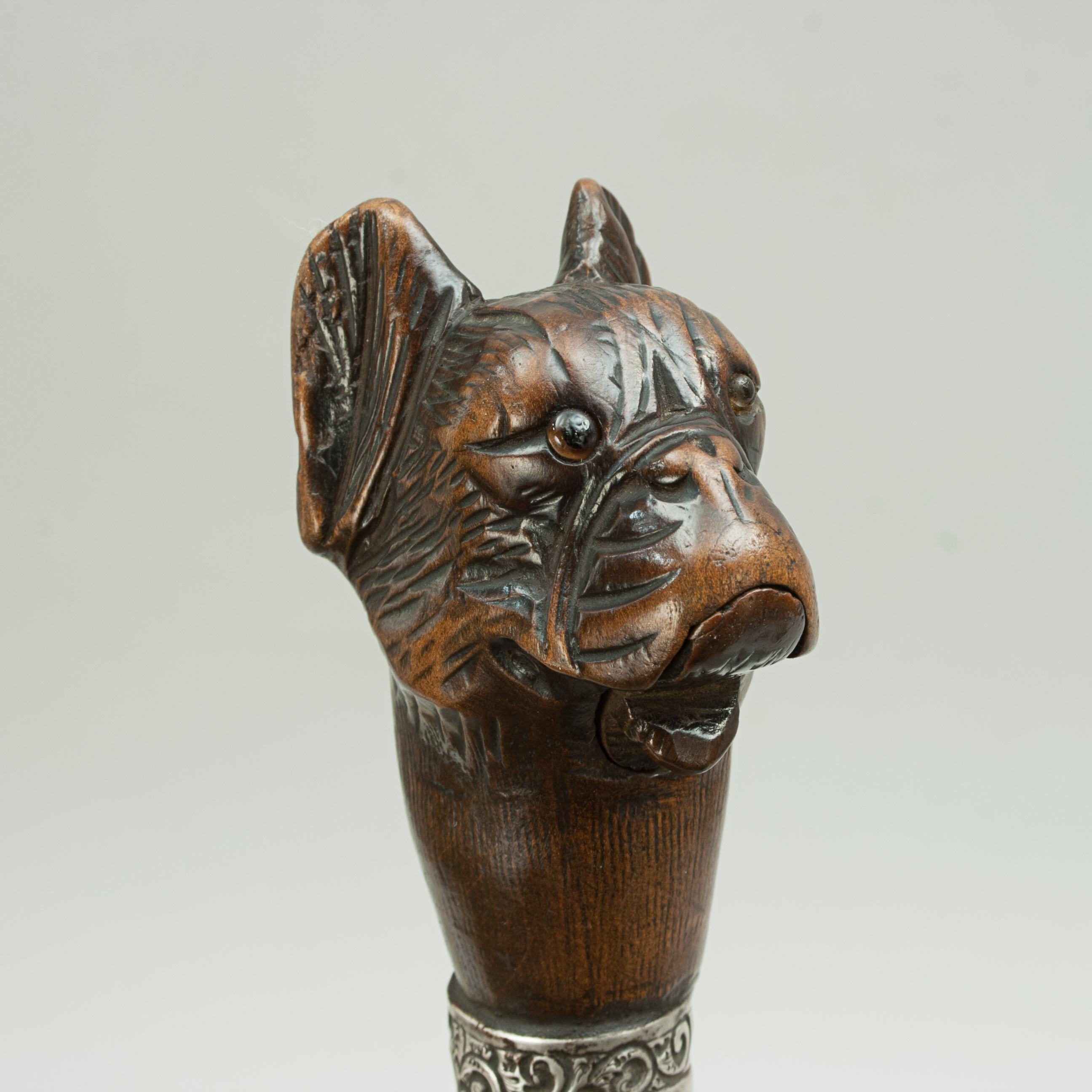 Bull dog head walking cane.
Early 20th century walking stick with an automaton dog head. The handle is a carved bulldog head, finely detailed, having inset amber glass eyes and spring-loaded opening mouth. The bull dog head mounted on Malacca cane