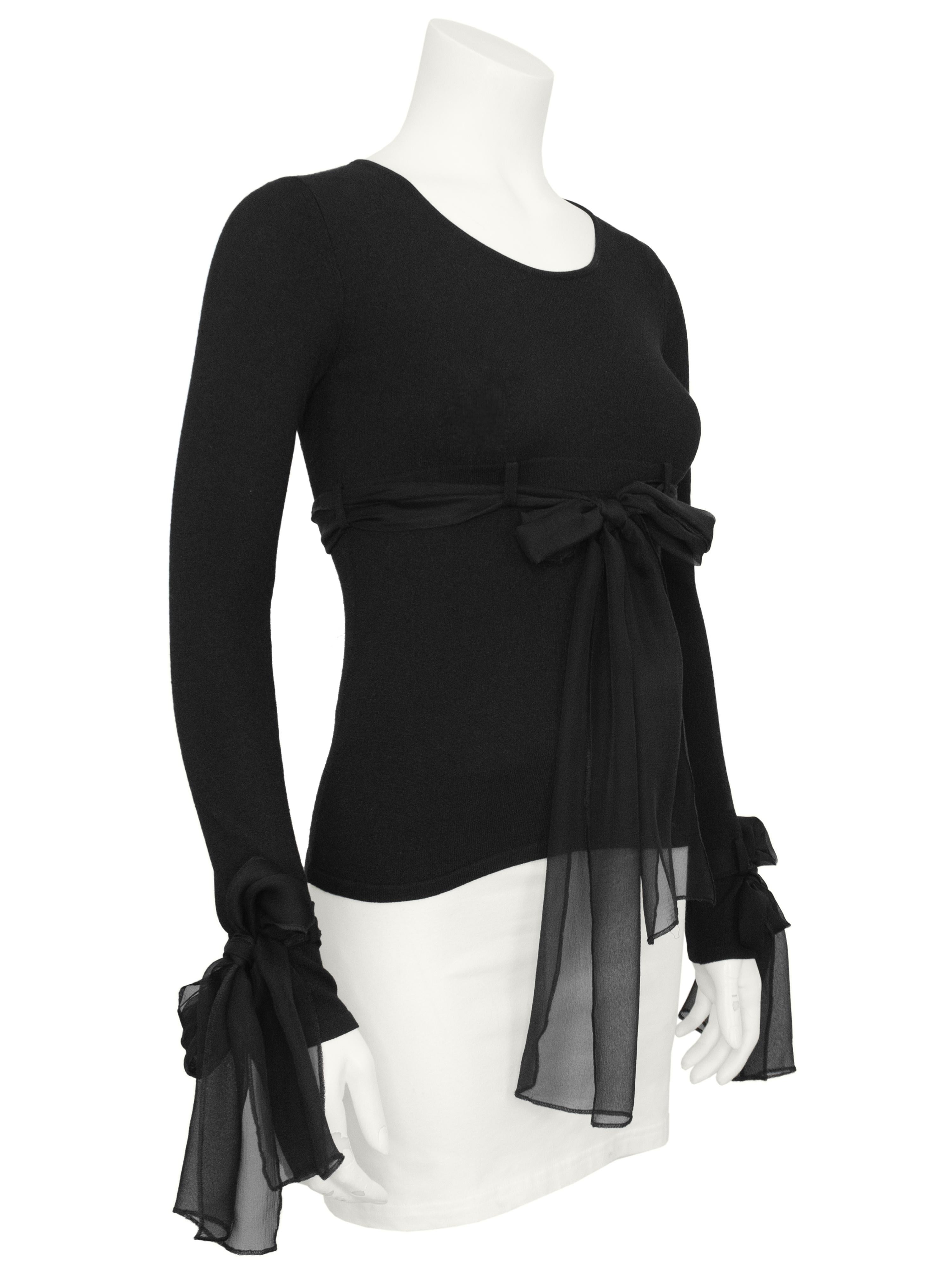 Gorgeous pullover sweater from the Chanel 2003 Autumn collection. The black rayon/polyester blend fabric is fitted on the body with lots of stretch. An empire waist is created with belt loops and a long black silk chiffon tie. Matching chiffon ties