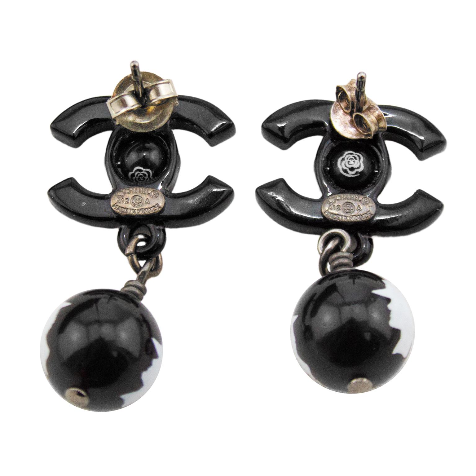 Chanel earrings from the Autumn 2012 collection. Black resin interlocking CC's with a tiny rotating ball in the centre with a white camellia flower on one side and a Coco Chanel cameo on the other and a drop ball with white Coco Chanel cameos on