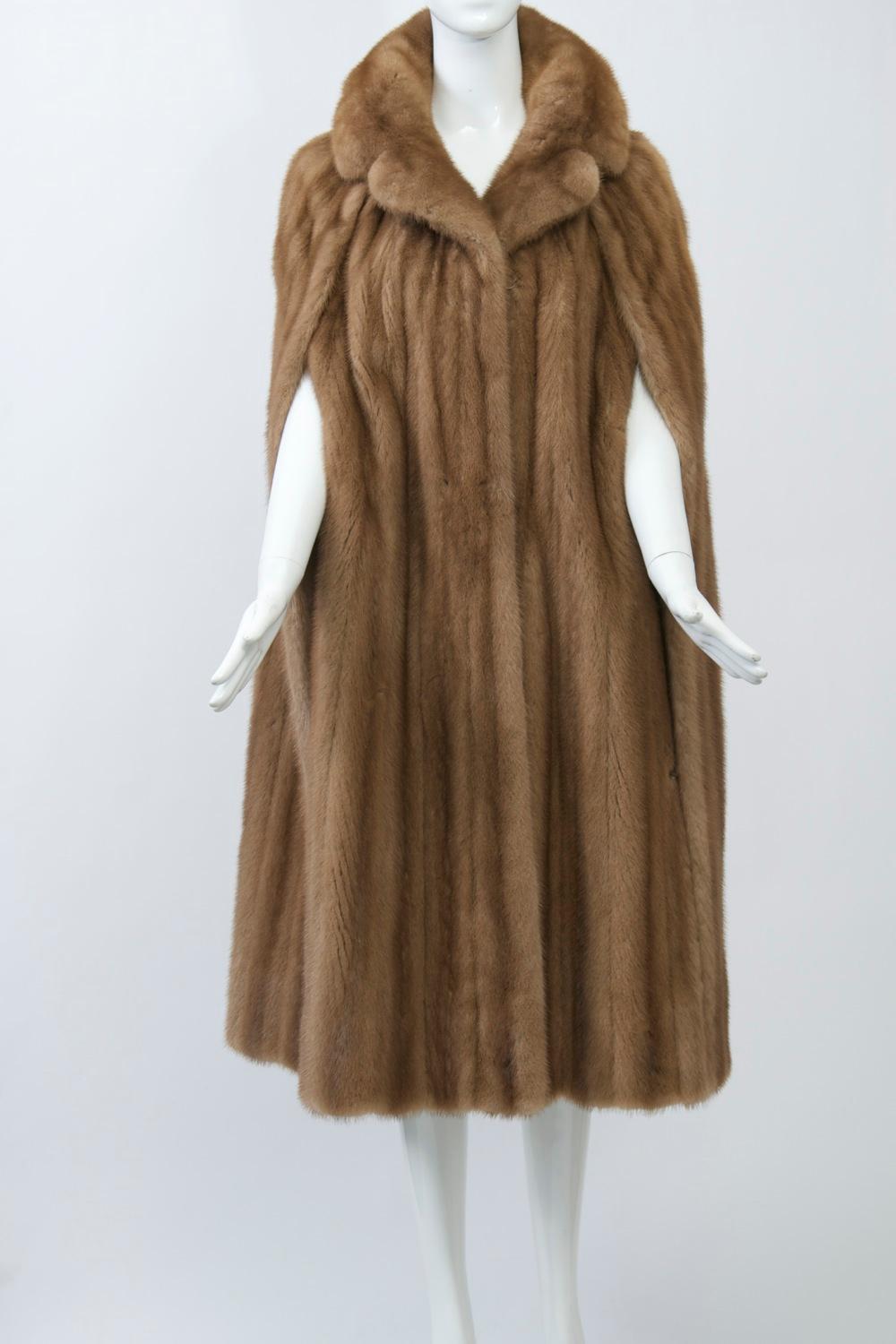 Two of my favorite things - capes and mink, combined into one fantastic piece. Fashioned of autumn haze mink, which is flattering and goes with everything, this cape has a notched collar and is slit down the sides, held in place by stitching across