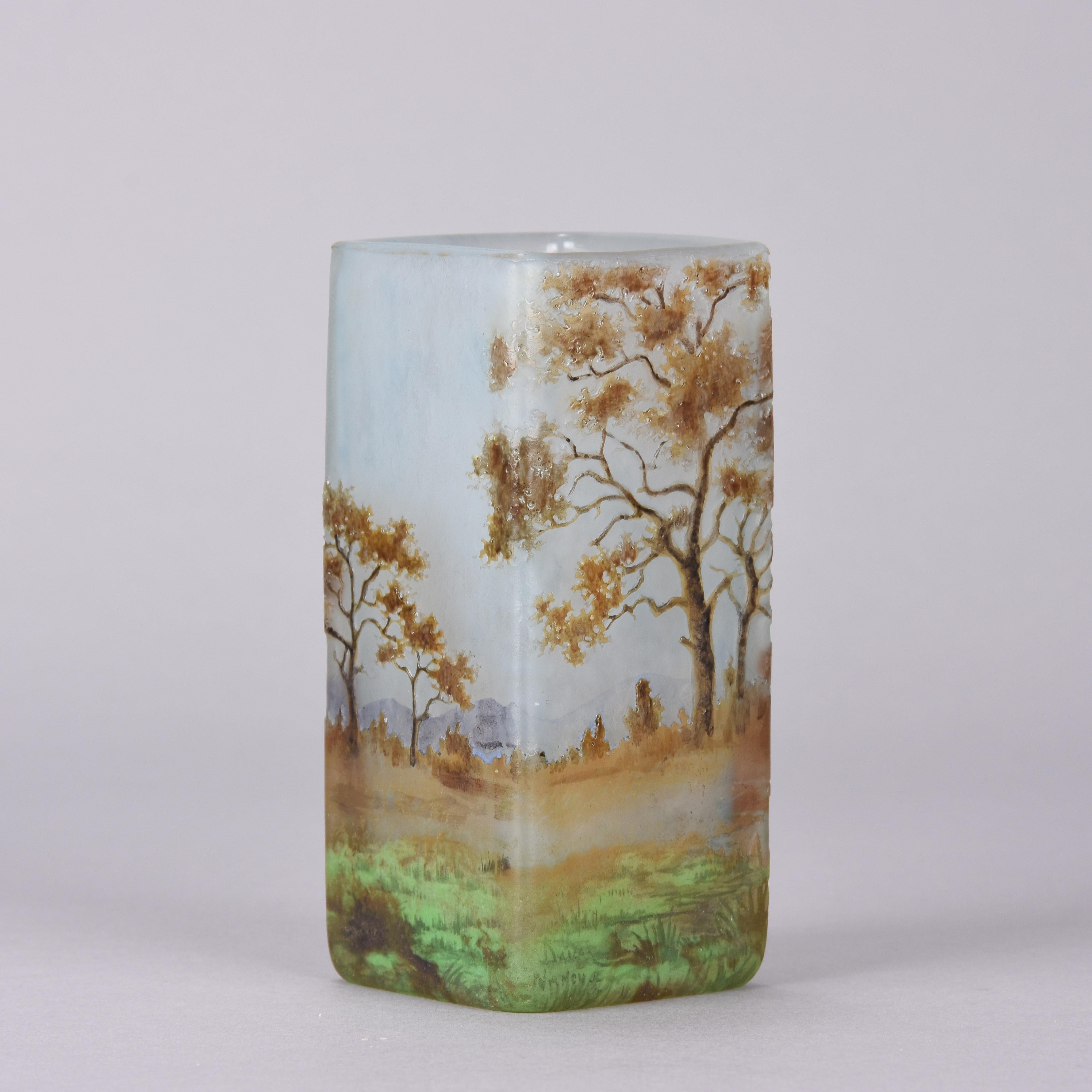 Exceptional rectangular shaped cameo glass vase etched and enameled with a rich autumn wooded landscape with lake. Signed Daum Nancy and with the Cross of Lorraine.
