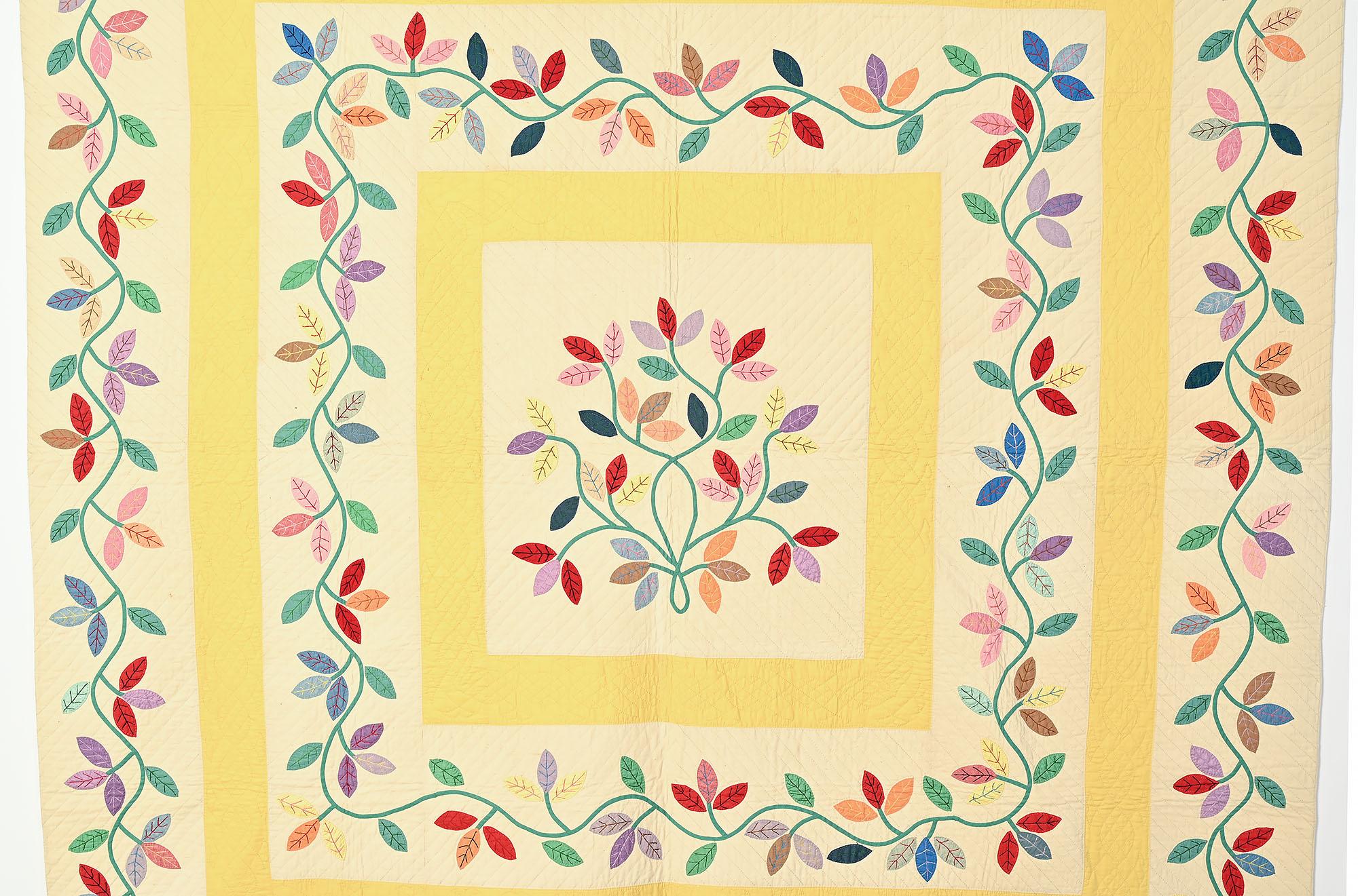 Although the name of this antique quilt pattern is Autumn Leaves, the choice of colors used here virtually screams Spring. A bouquet of flowers or leaves fills the center panel. Two frames of soft, buttery yellow surround two rows of undulating