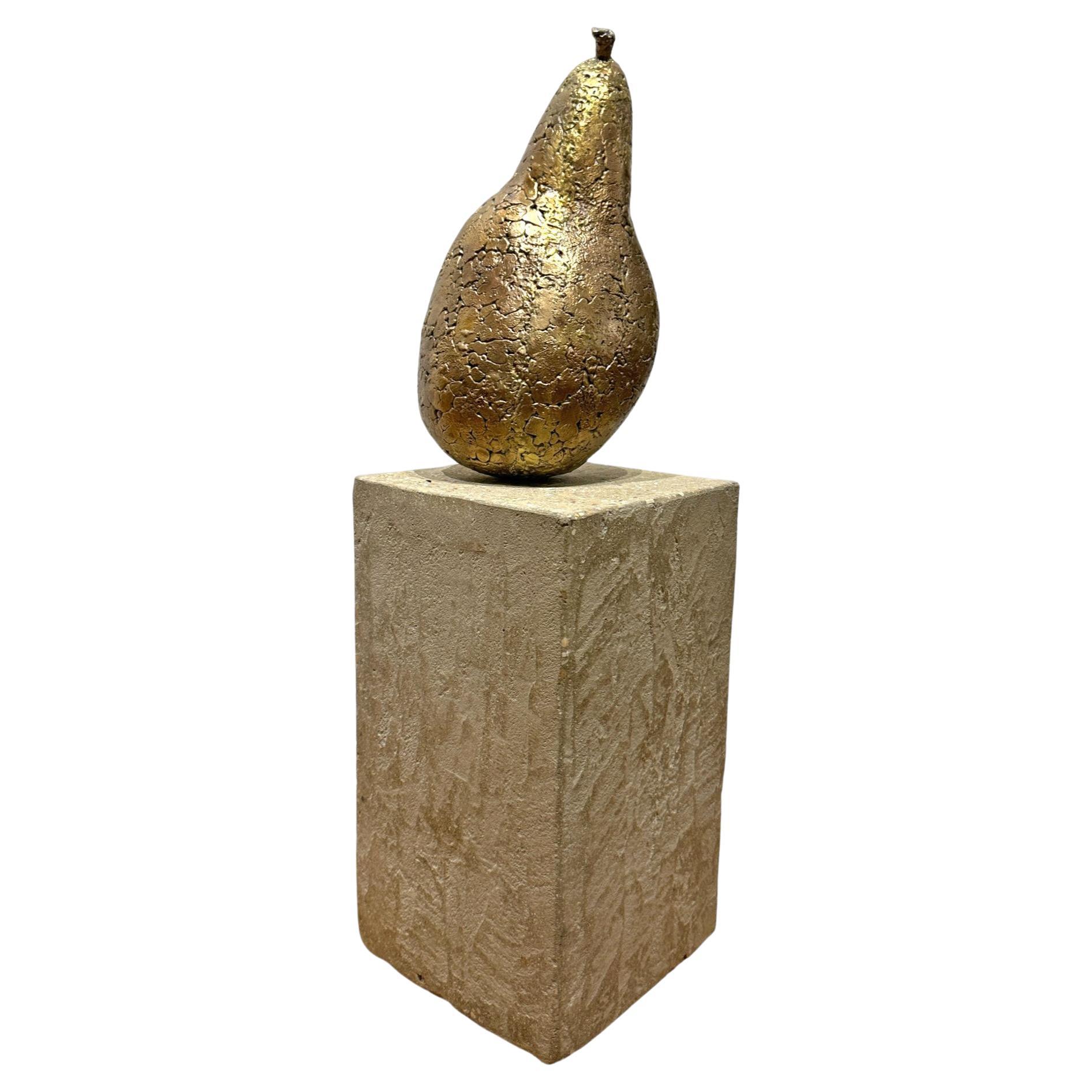 An oversized bronze pear sits upon a concrete base in Mary Block's unique work entitled Autumn Pear. This one of a kind bronze sculpture is perfect in its imperfect shape as only nature can produce. The surface of the bronze is a smoothed mosaic of