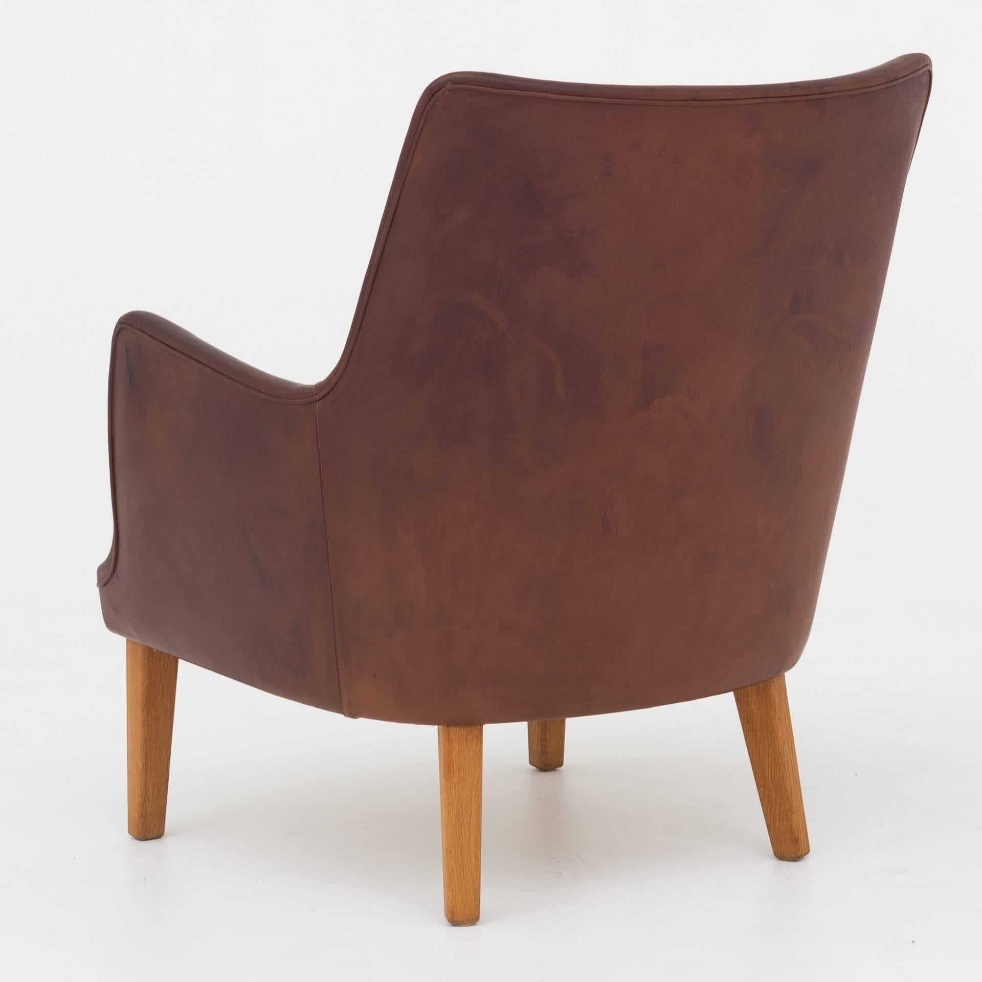 Easy chair by Arne Vodder with oak legs and patinated brown leather. Maker Ivan Schlechter.