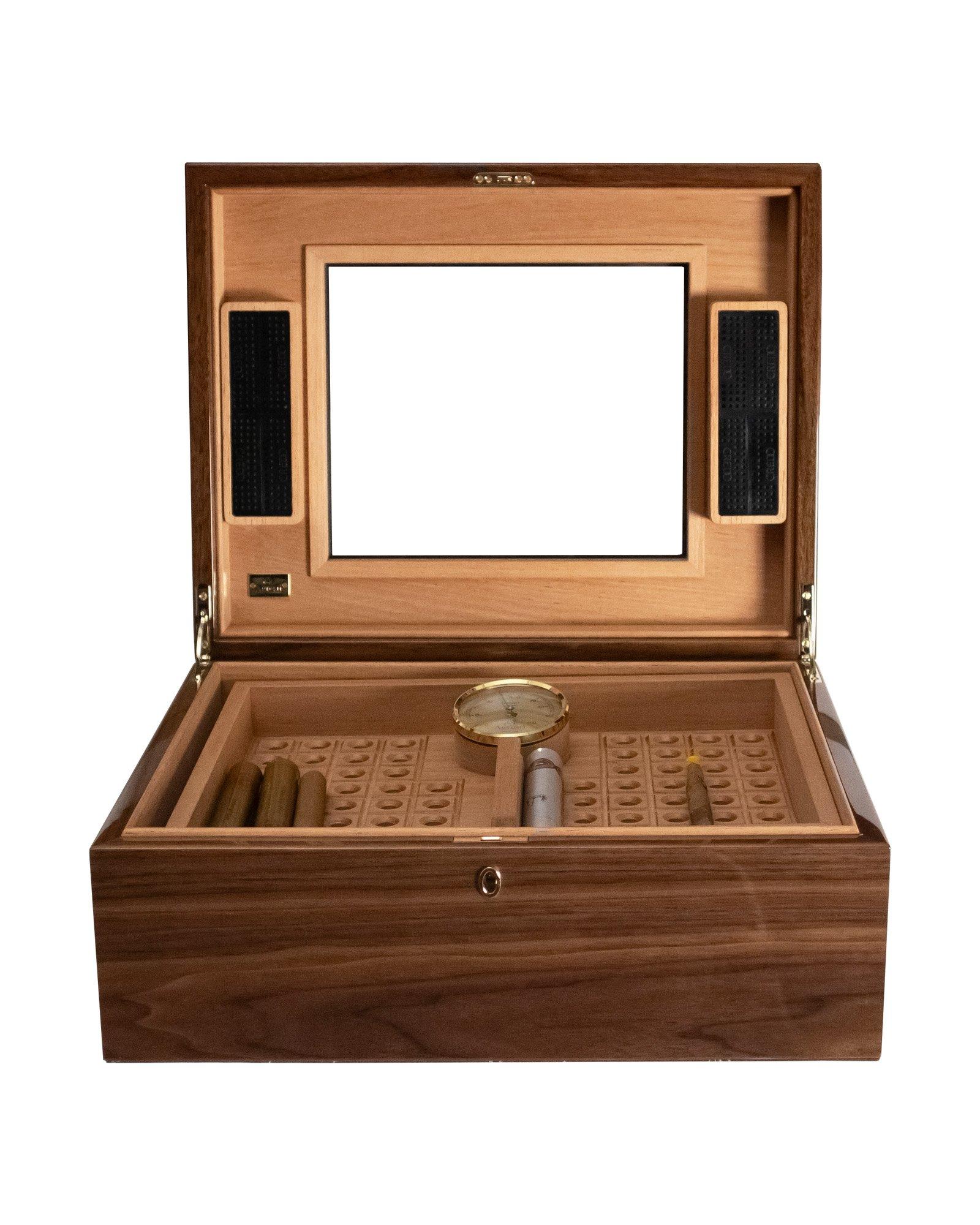 Humidificateur pour 100 cigares en bruyère d'orme polie et en acajou. Intérieur en cèdre de première qualité. Deux unités d'humidification et un hygromètre de fabrication allemande. Plateau amovible avec texture gravée. Fermeture par serrure avec