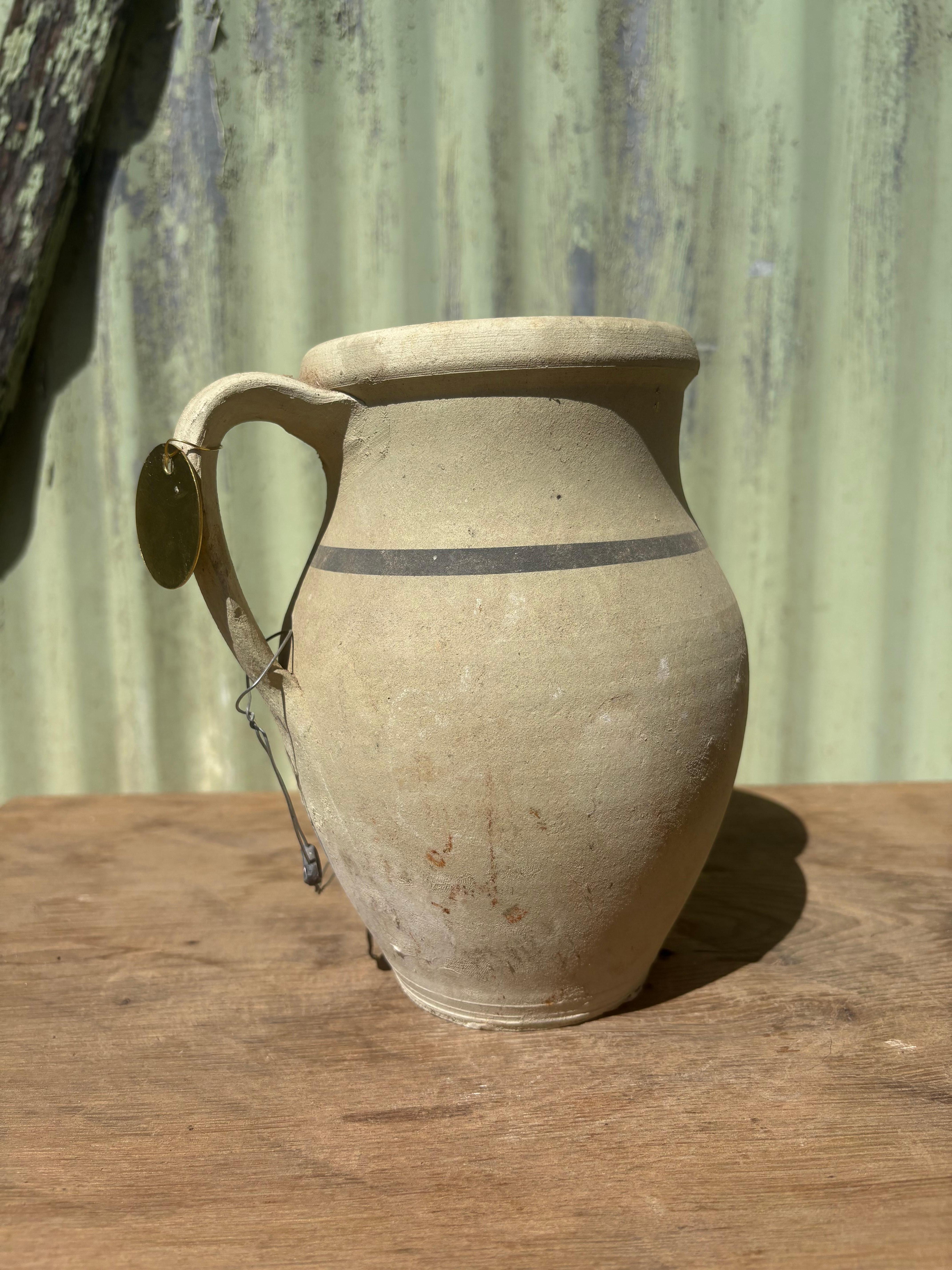 Questo vaso turco extra piccolo con un manico e una striscia proviene da Avanos: una città situata nella regione della Cappadocia, in Turchia, che un tempo attraversava la storica via commerciale della Via della Seta. Questo pezzo è stato creato in