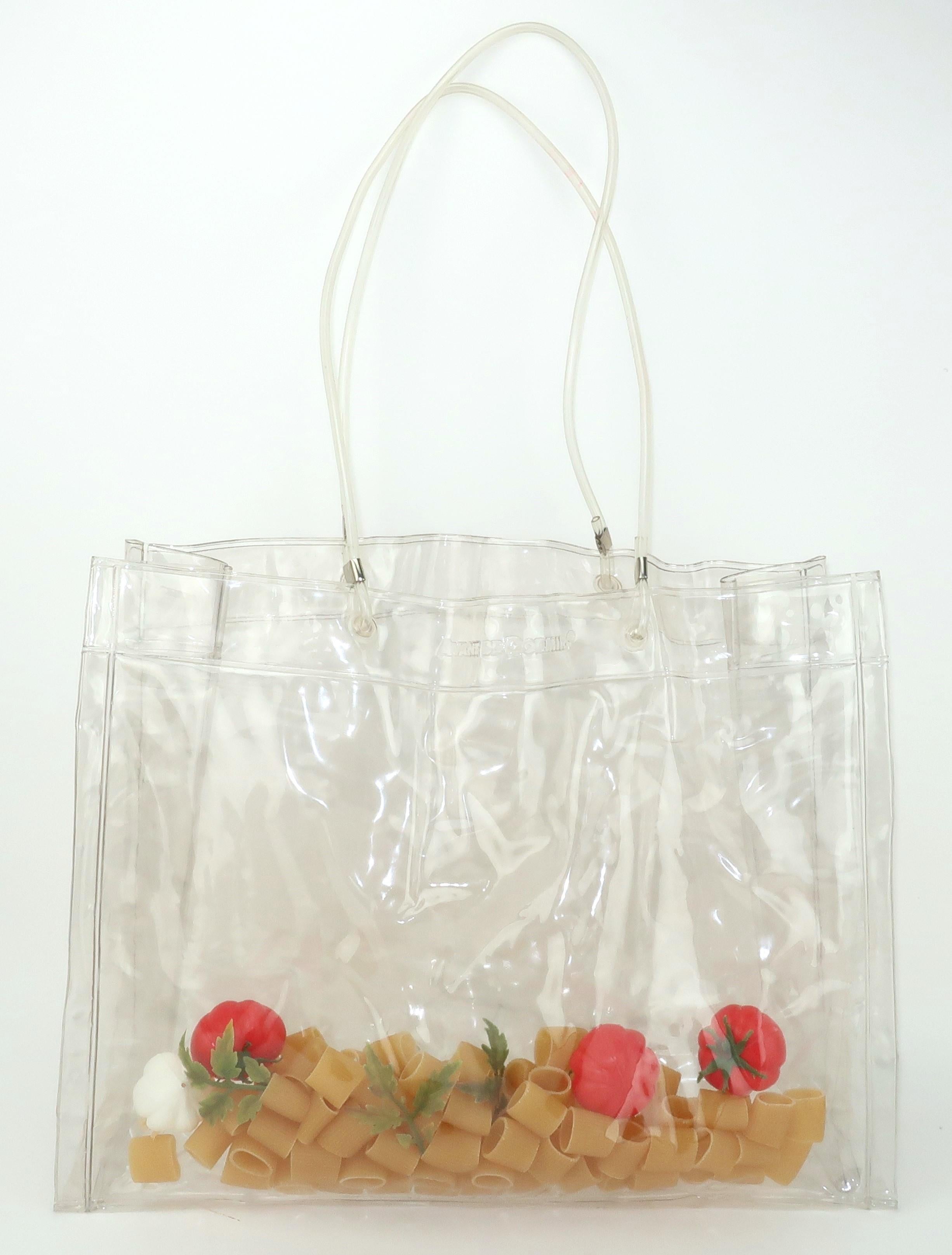 1980’s clear vinyl ‘Flashbags’ tote handbag by Italian design duo, Avant de Dormir.  The clear vinyl serves as a clever window to a mix of a dinner ingredients … pasta, tomatoes, garlic and parsley.  Just a touch of surrealism for this fashion