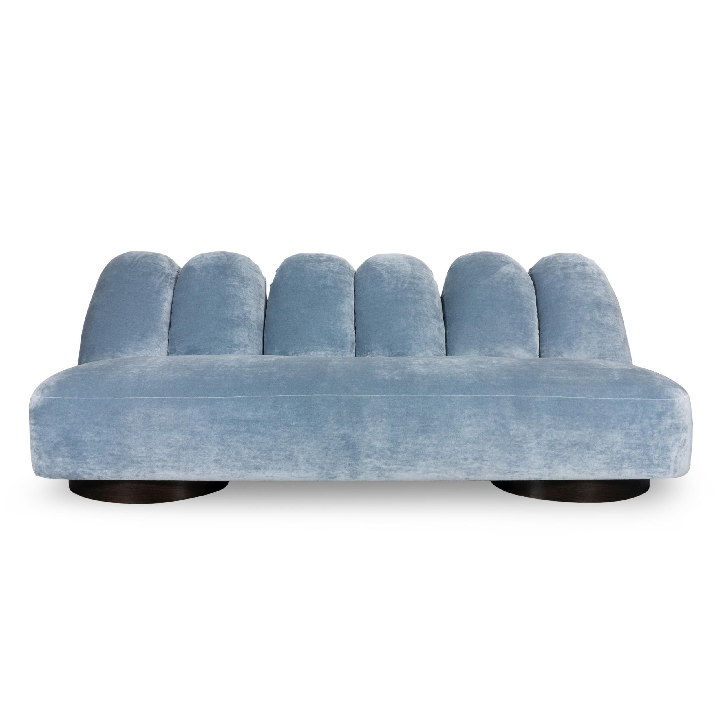 Sofá de diseño vanguardista con canales jumbo emparejados que se asemejan ligeramente a dedos de mujer desde el respaldo y equilibrados con un único asiento corrido ajustado. El exterior de la espalda revela detalles primarios de piel de anguila