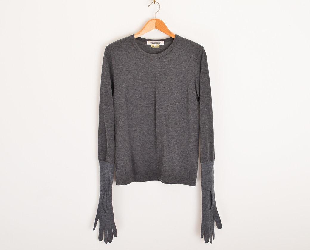 Incredible Archival COMME des GARÇONS Pure Wool sweater with long gloved sleeves in Charcoal Grey designed by Rei Kawakubo from the 2012 collection. 
 
Features;
Gloved design with wrist slits
Rounded neckline
Stretchy fit
100% Pure Wool
