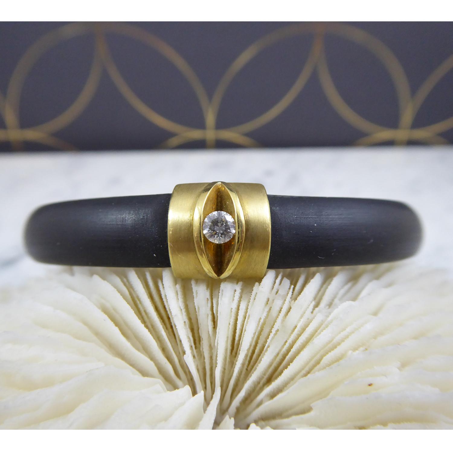 Fabulous directional design diamond bracelet by German jewellery designer, Bunz. Meticulous attention to detail with a black silicone band with a section of 18ct yellow gold. A 'slice' has been cut out of the gold section and a brilliant cut diamond