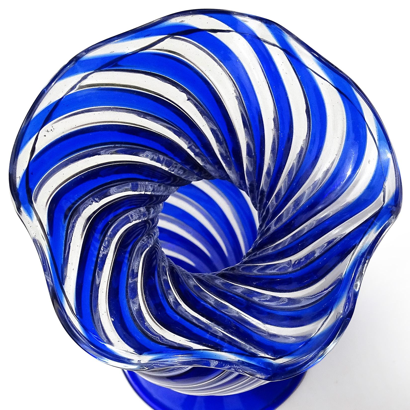 Beautiful vintage Murano hand blown swirling cobalt blue and clear Italian art glass flower vase. Documented to Arte Vetraria Muranese (A.Ve.M.). Created in the “A Canne” technique. It has a ruffled rim, and applied large foot. Would make a great