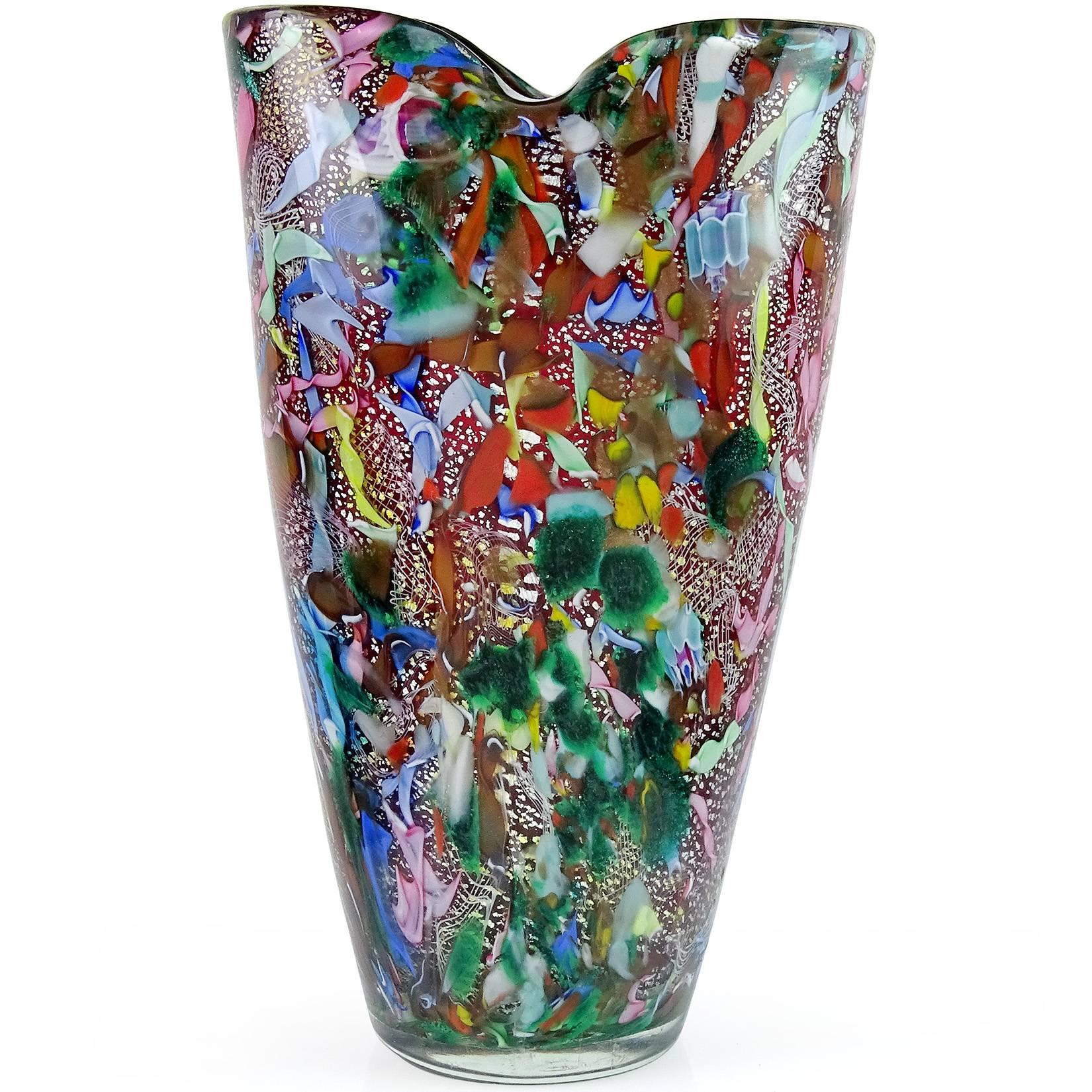 Beautiful vintage Murano hand blown red, silver flecks, green aventurine, millefiori murrines and twisted ribbons Italian art glass flower vase. Documented to the A.Ve.M. (Arte Vetraria Muranese) company. The piece has a pinched rim. Mid Century