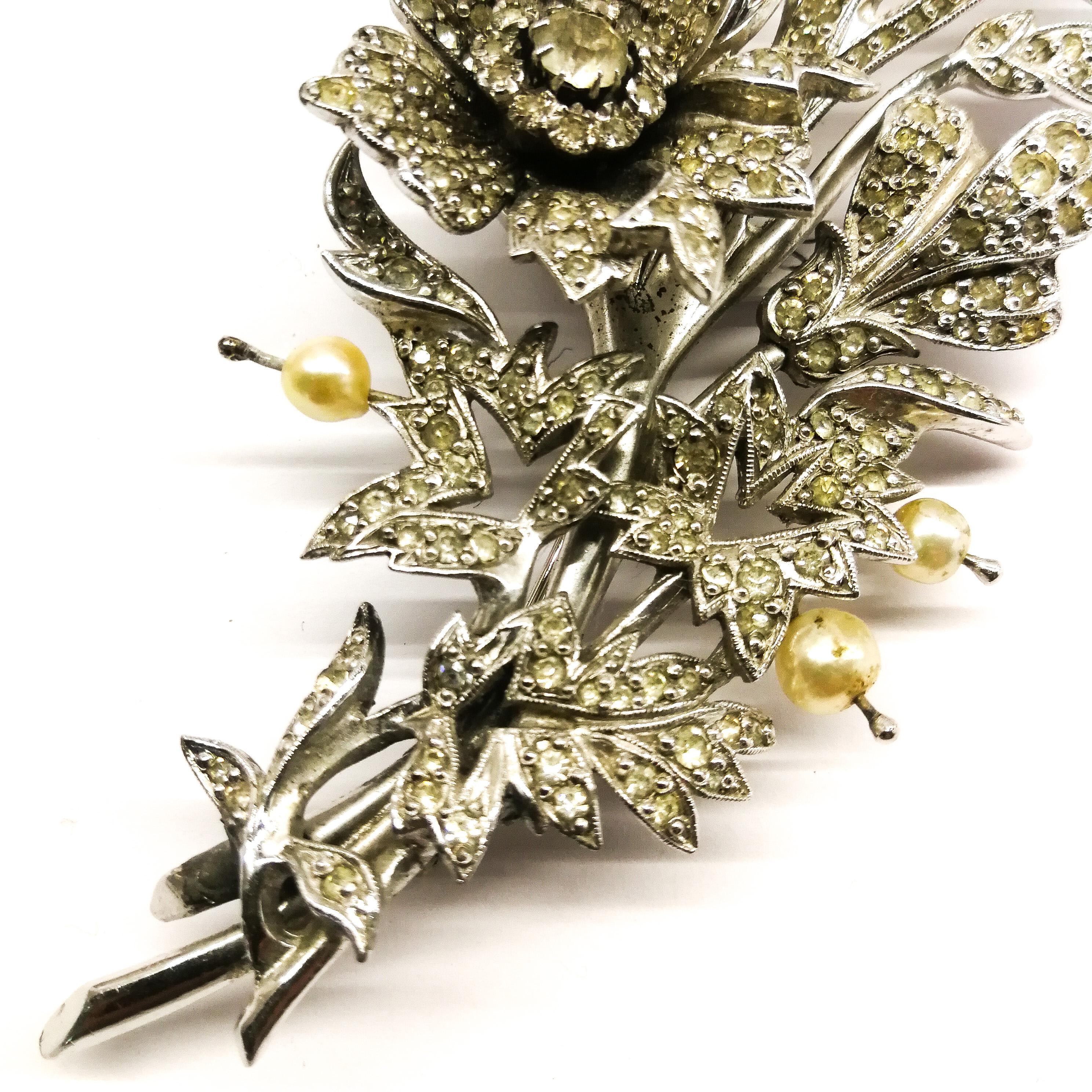 A very rare and elegant brooch from Christian Dior, made by Mitchel Maer, depicting a rose 'en tremblant', a glorious spray, from the early 1950s. Made of clear paste set in rhodium metal, it is highlighted with baroque prong set paste pearls.