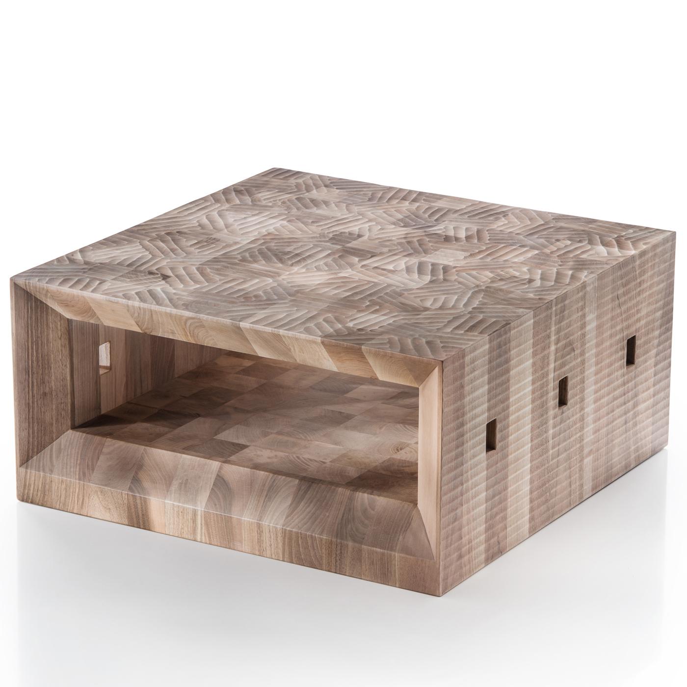 This striking coffee table is carved out of a single piece of Italian walnut wood and hand-finished in full relief with a gouge. The sides, inside, and top feature different decorative patterns in a harmony of geometrical and sinuous shapes.