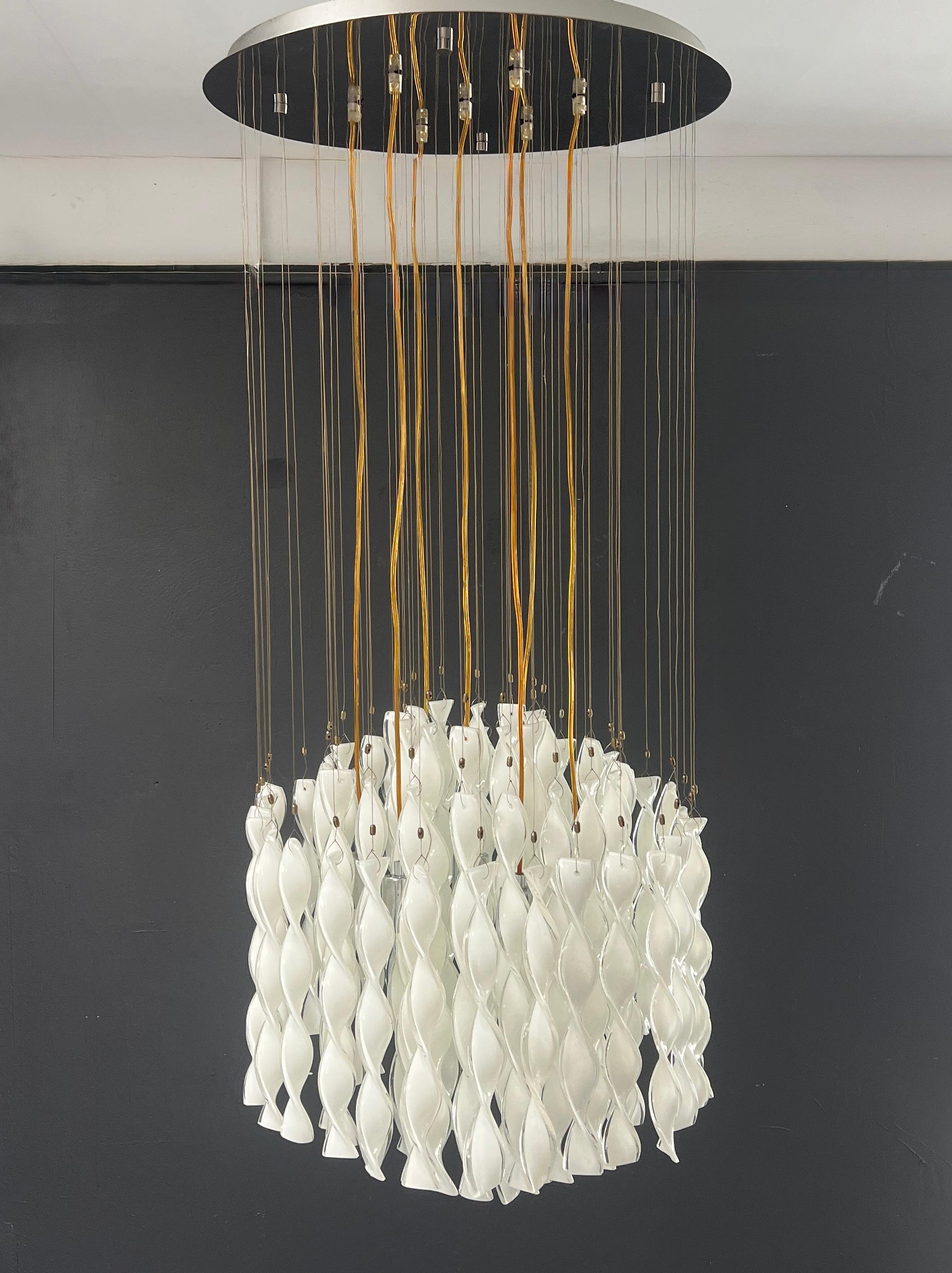 Illuminez votre espace avec la suspension Avir d'Axolight, une création étonnante de Manuel et Vanessa Vivian. Whiting 62 pendentifs en verre de Murano à triple couche, tordus à la main, ses délicats fils blancs créent un jeu de lumière et de