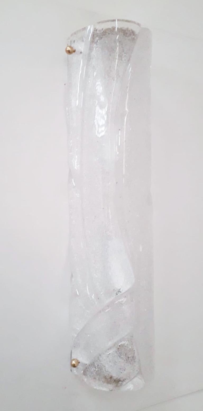 Wandleuchte im italienischen Art-Déco-Stil aus klarem Murano-Glas mit strukturiertem Granulat-Effekt in Graniglia-Technik, mundgeblasen für ein stilvolles, gewickeltes oder umhülltes Muster, montiert auf weißer Grundplatte und Endplatten aus Messing