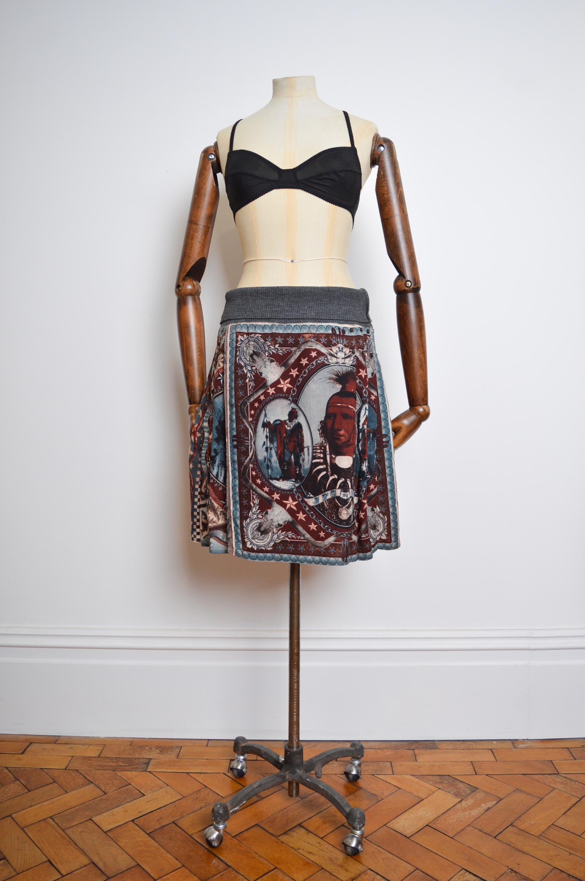 Superb A/W 1994 native american print wool kilt skirt by Jean Paul Gaultier crafted from a printed wool cloth with Metal rivet detailing and fold over knitted waistband.

MADE IN FRANCE !

Recommended size UK 8-12. (this depends on wether you wish