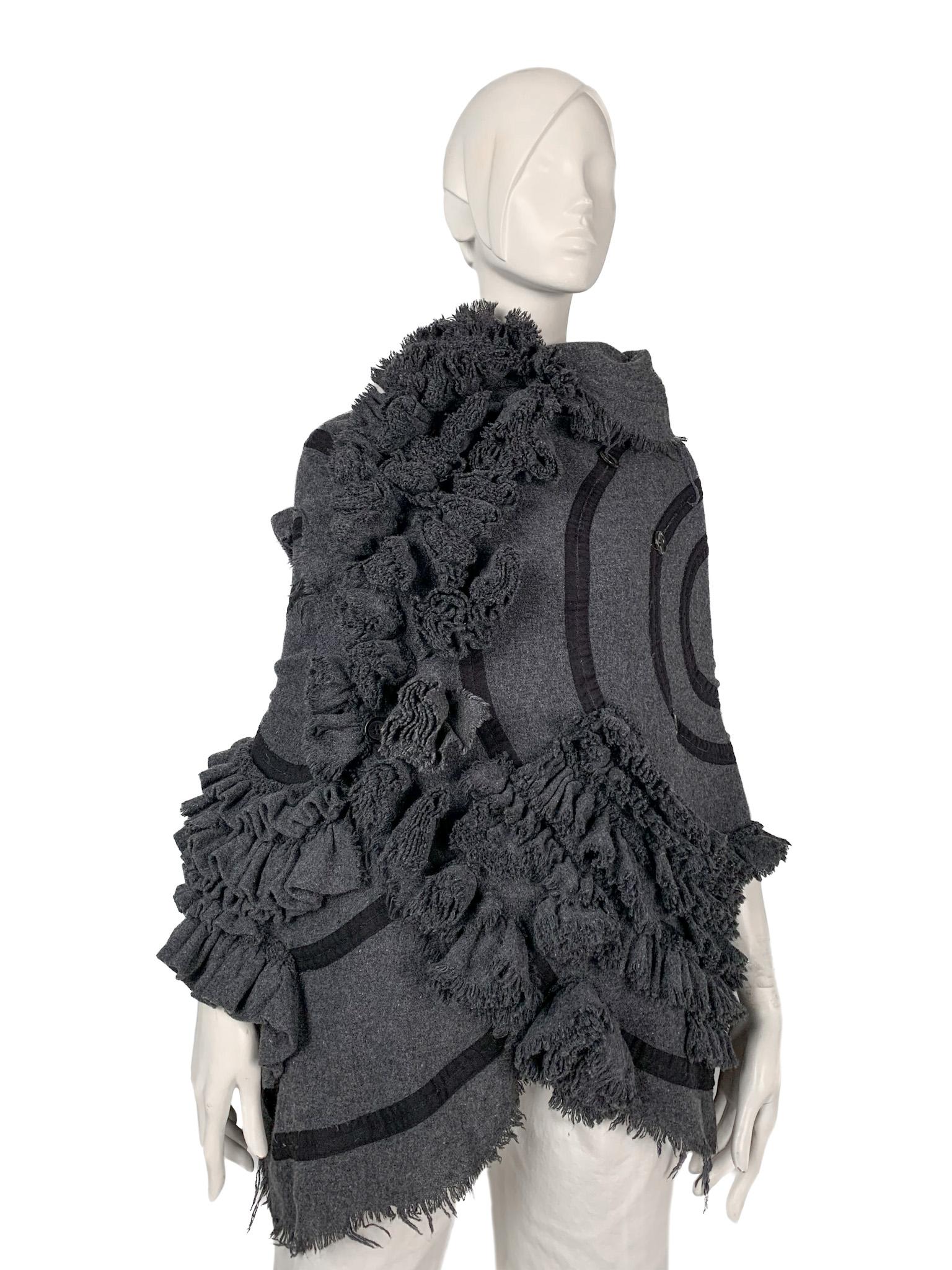 TAO Comme des Garcons AW 2006 cape/knitwear piece with asymmetric three-dimensional appliques.
A truly avant-guarde creation, allowing for endless options of wearing it. It consists of two huge pieces of fabric interconnected with functional