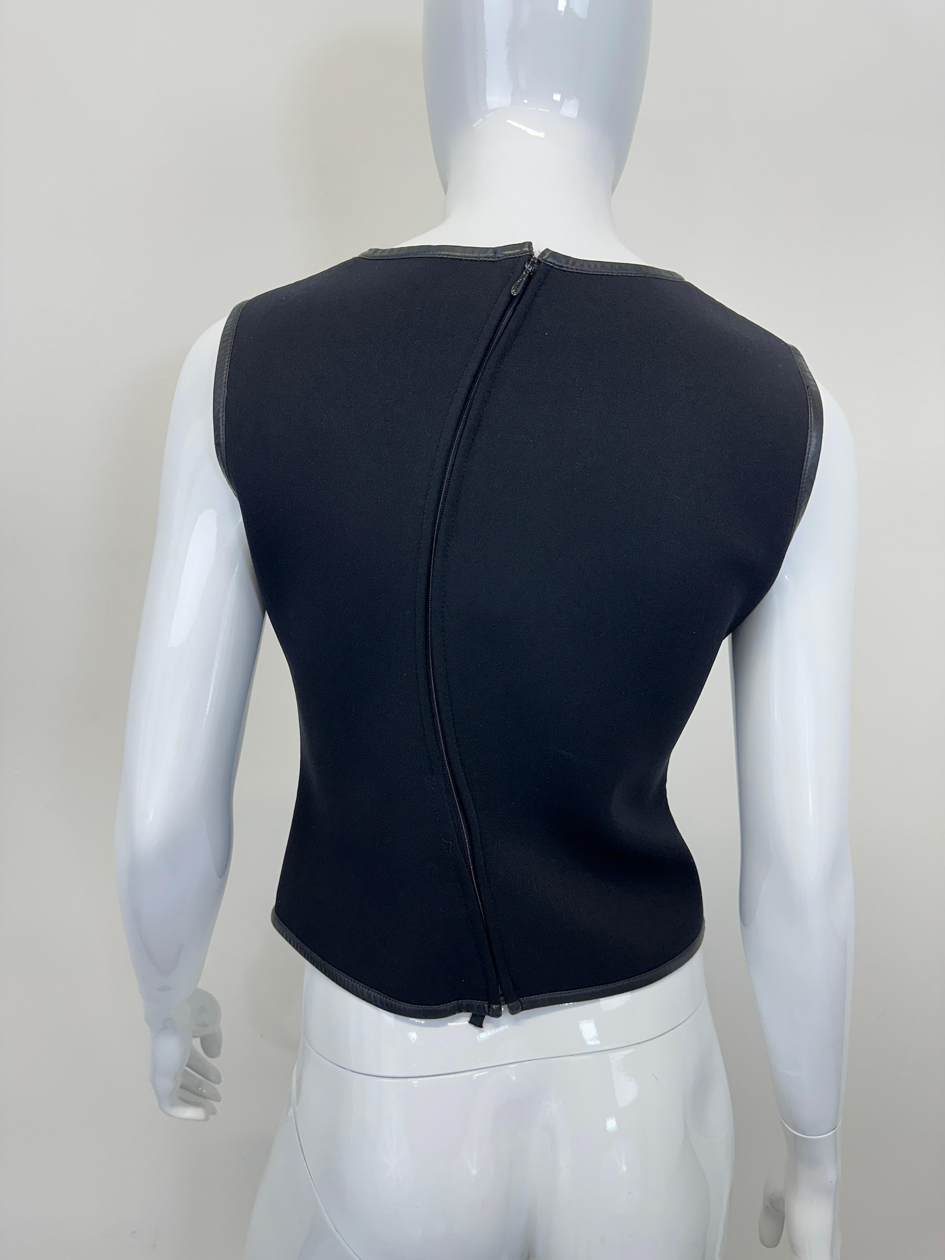 a sleeveless black wool Gucci shirt, designed by Tom Ford. From the Fall/Winter 1999 collection, this top features leather trim and a curved asymmetrical seam and zipper at the back. Insane quality and attention to details, avant-garde design ahead