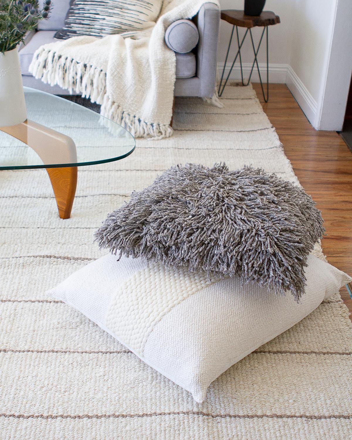 A shaggy pillow to brighten your living room. Introducing Awanay Sur Pillows - our wildly fun, handmade wool pillows with a playful twist. Fair trade and totally boho, these shag pillows are the perfect addition to any home decor! Superbly gray and