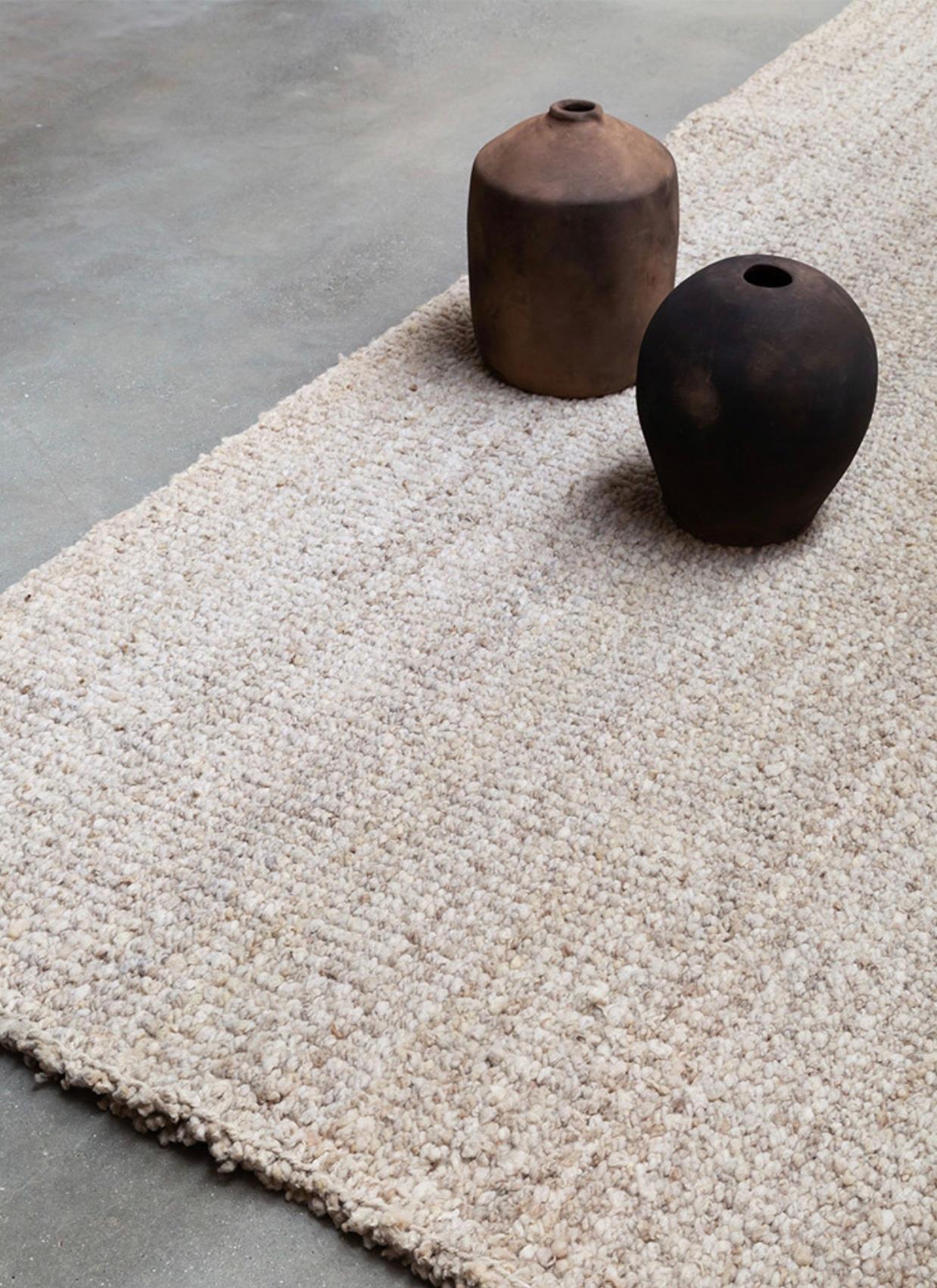 Transform your living space with our Wool Area Rug in Jume. Handwoven by skilled artisans in Argentina, this large rug boasts a medium weave and organic modern design in rustic beige and siena colors. Made with hand dyed, natural wool, it's perfect