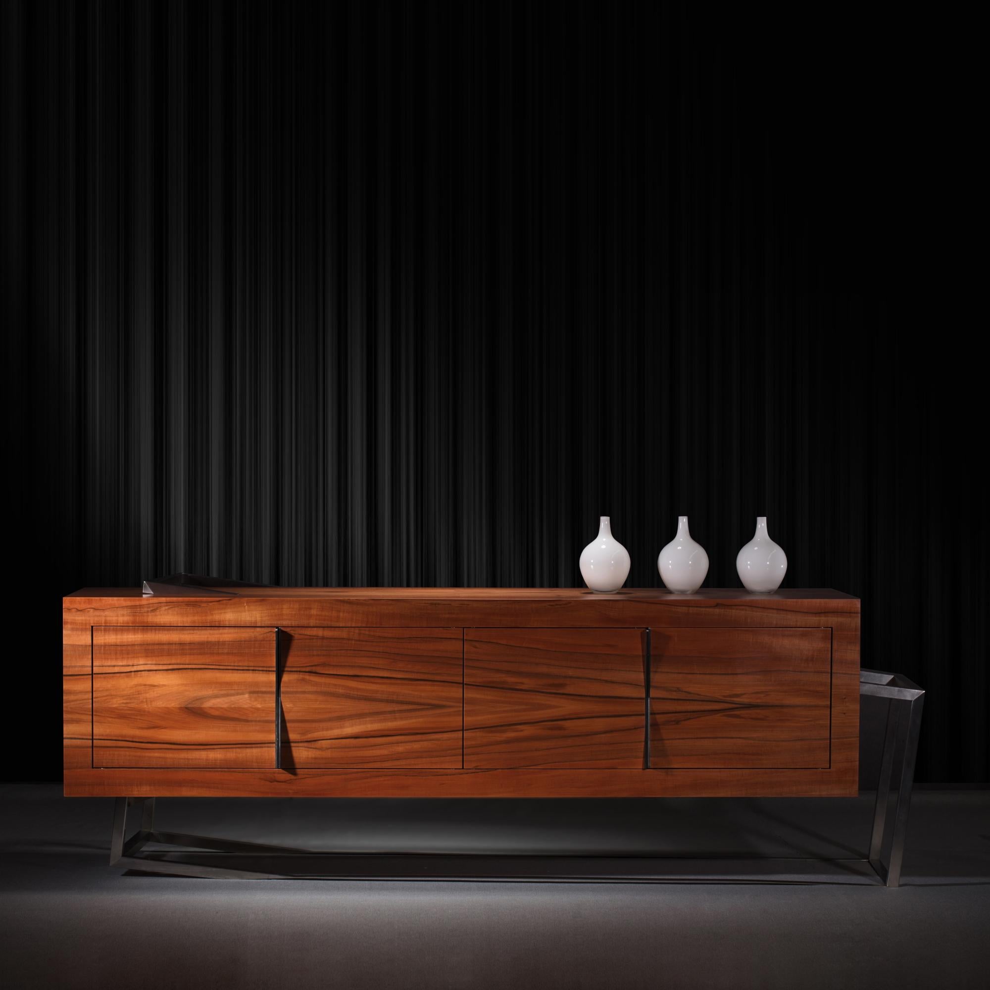 El Aparador Credenza ExCentric 1.0 está hecho de madera de tineo y acero inoxidable cepillado, y puede colocarse en un comedor o en un despacho. Su diseño contemporáneo y vanguardista desafía las percepciones de un aparador habitual. Esta pieza