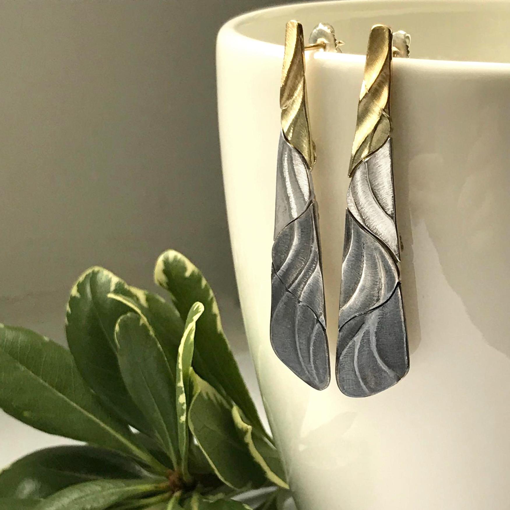 Ombre is the blending or shading of one color hue into another. K.MITA’s Ombre Earrings, which are 54 x 12mm and have two hinges to enhance movement, blend Argentium and Oxidized Silver with 18k Yellow Gold and 14k Green Gold to create the effect of